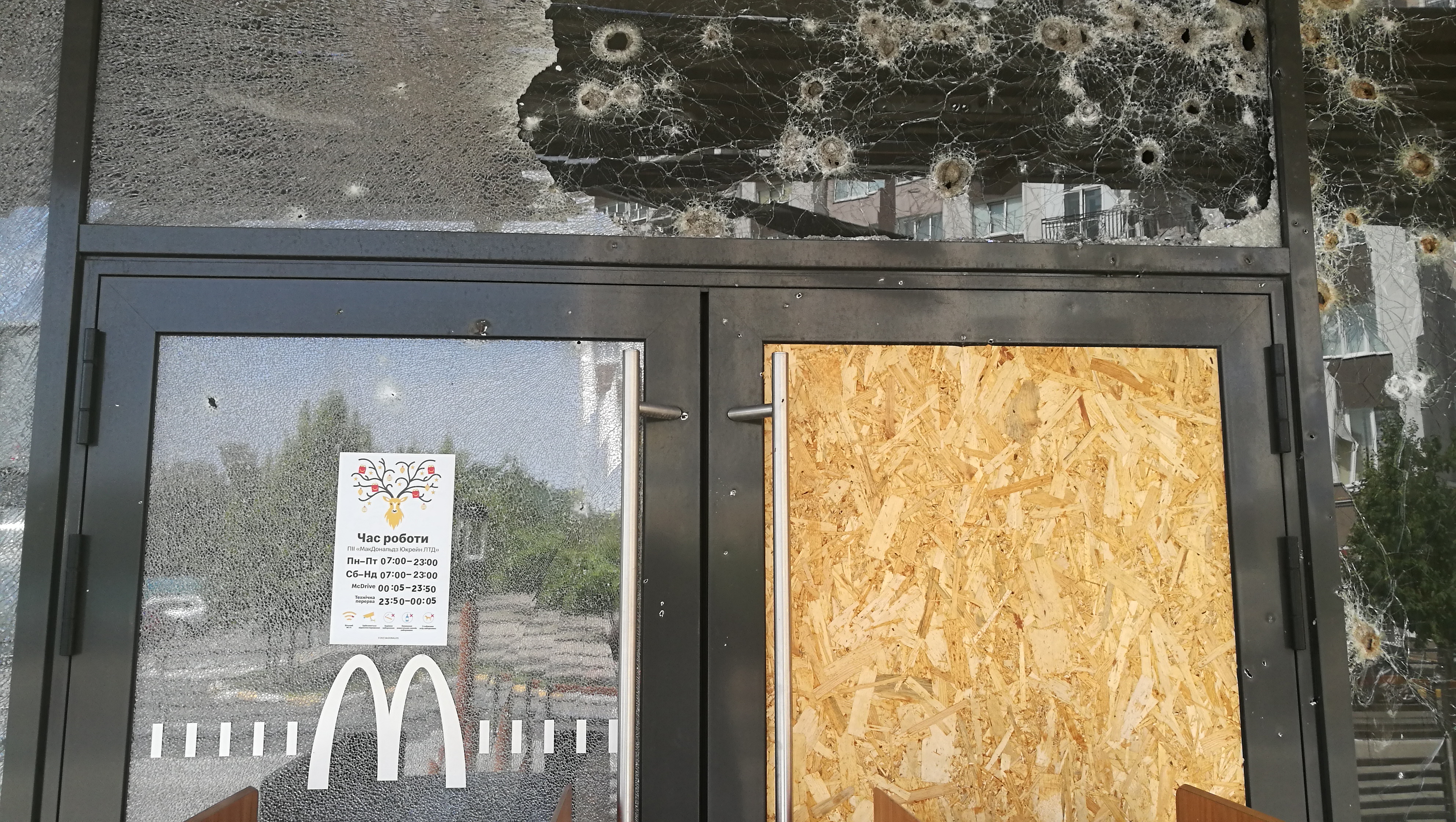 A bullet riddled glass wall of a McDonals restaurant in Bucha