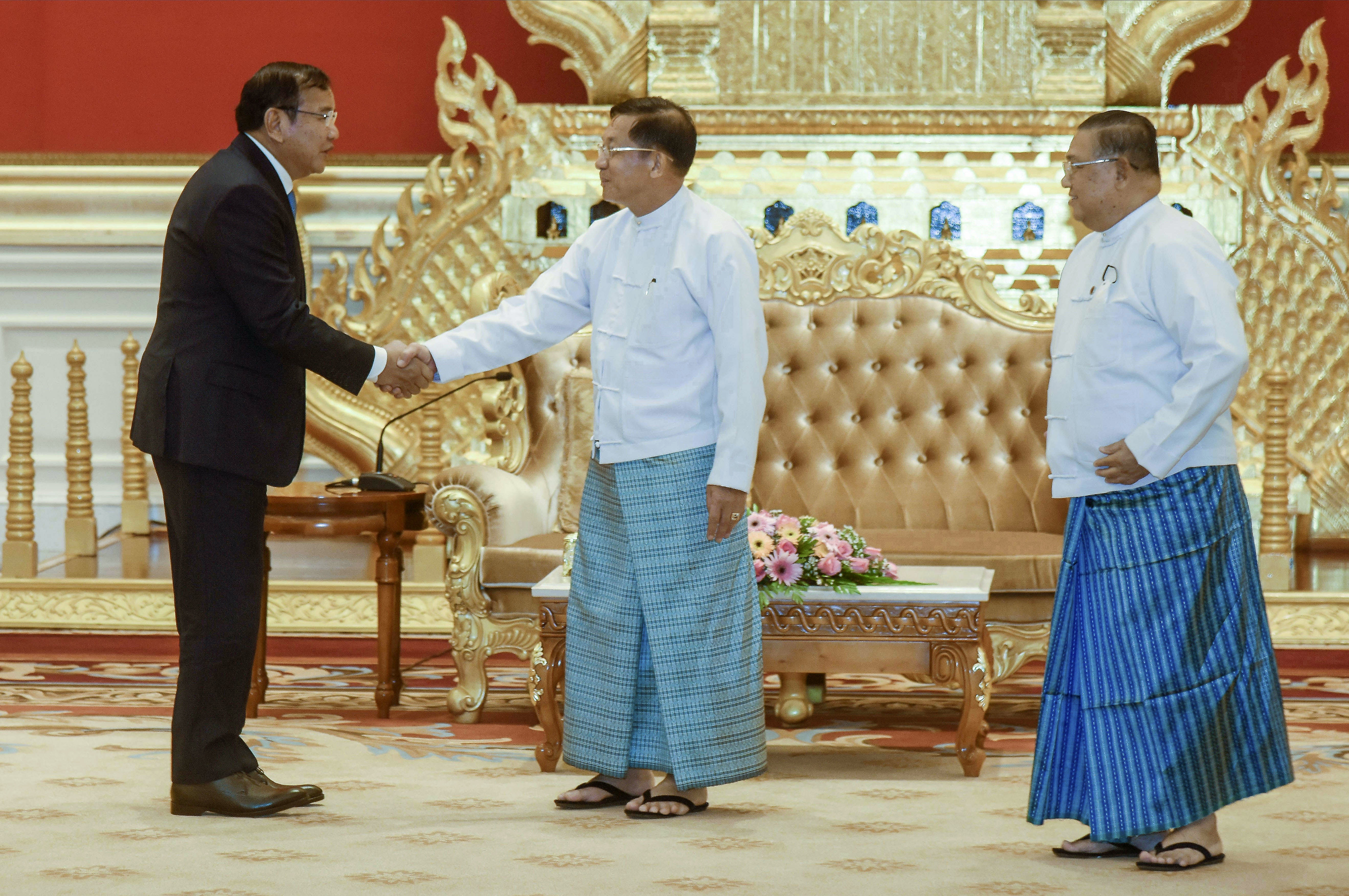 Prak Sokhonn, Cambodia foreign minister and ASEAN special envoy on Myanmar, shakes hands with coup leader Min Aung Hlaing on a visit to Myanmar