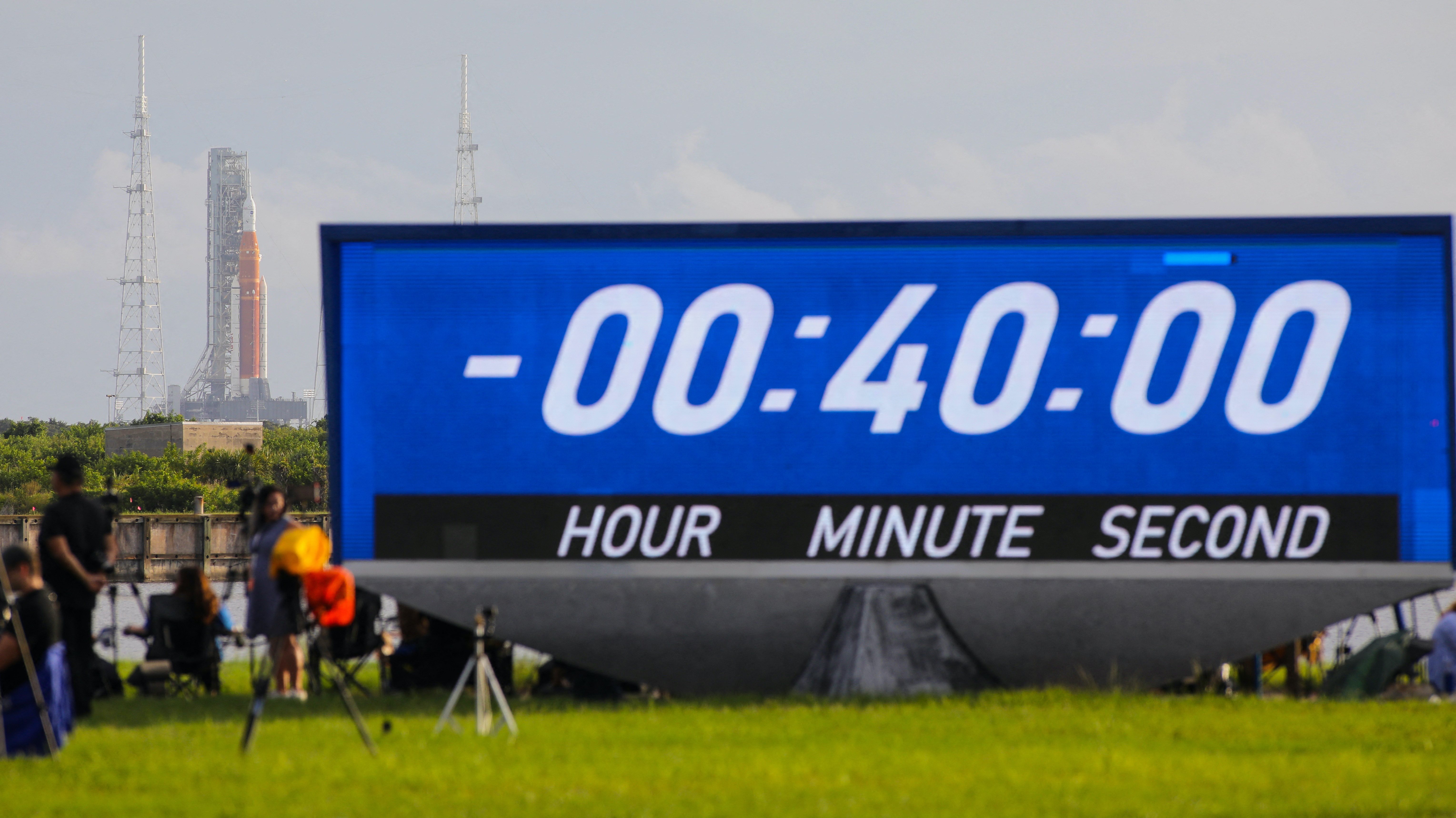 News media members wait and NASA's next-generation moon rocket, the Space Launch System (SLS) , with its Orion crew capsule on top, sits on the pad before the launch of the Artemis I mission was scrubbed, at Cape Canaveral, Florida, U.S.