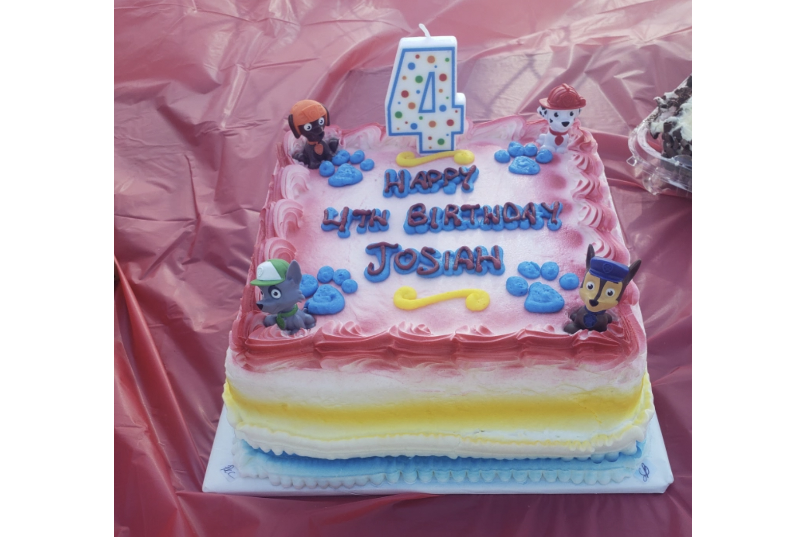 A photo of a birthday cake with a candle shaped like the number four on it and it has the words