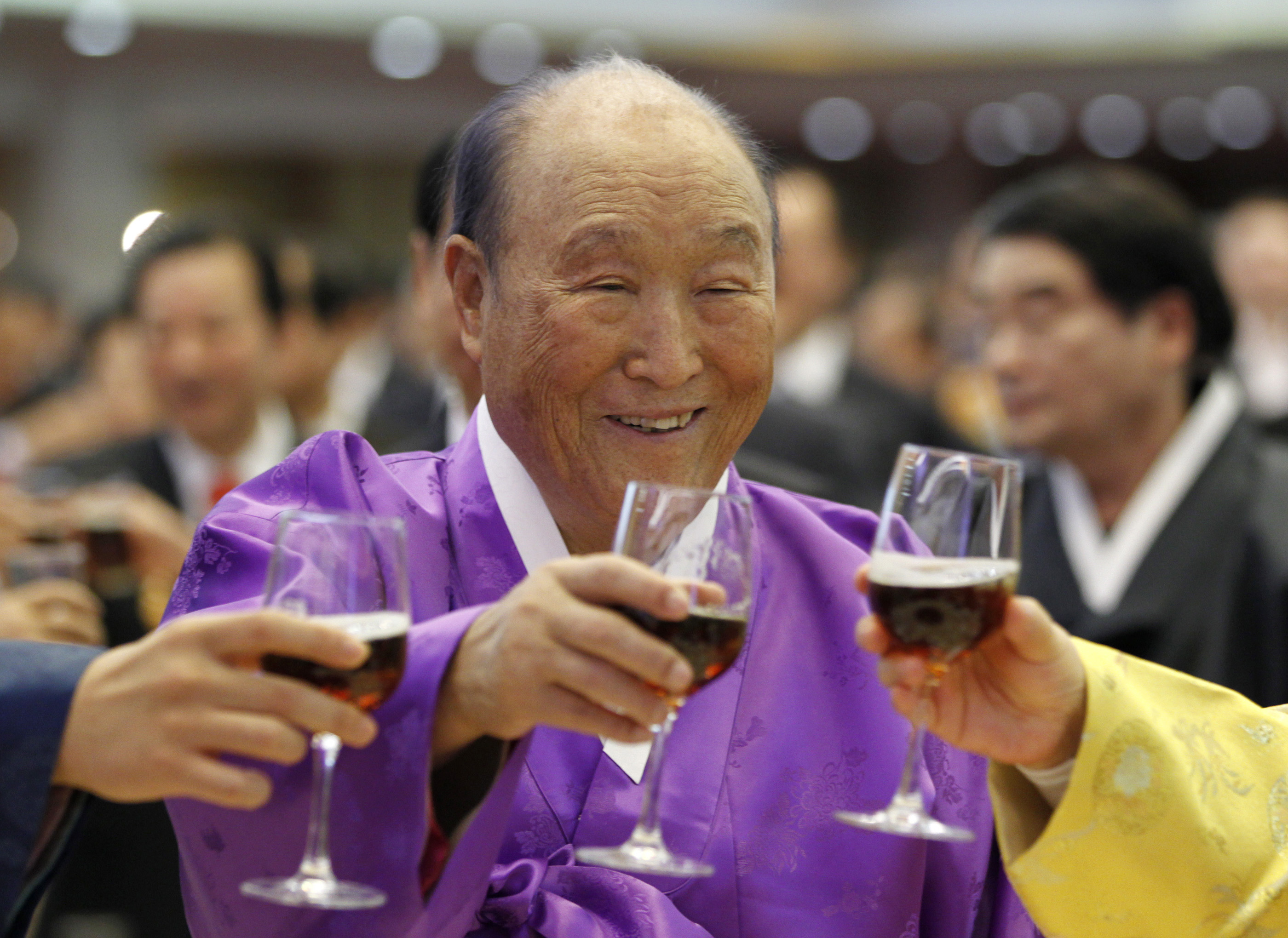 Moon Sun Myung, the founder of the Unification Church, drinks a toast with his family members during his 91st birthday party