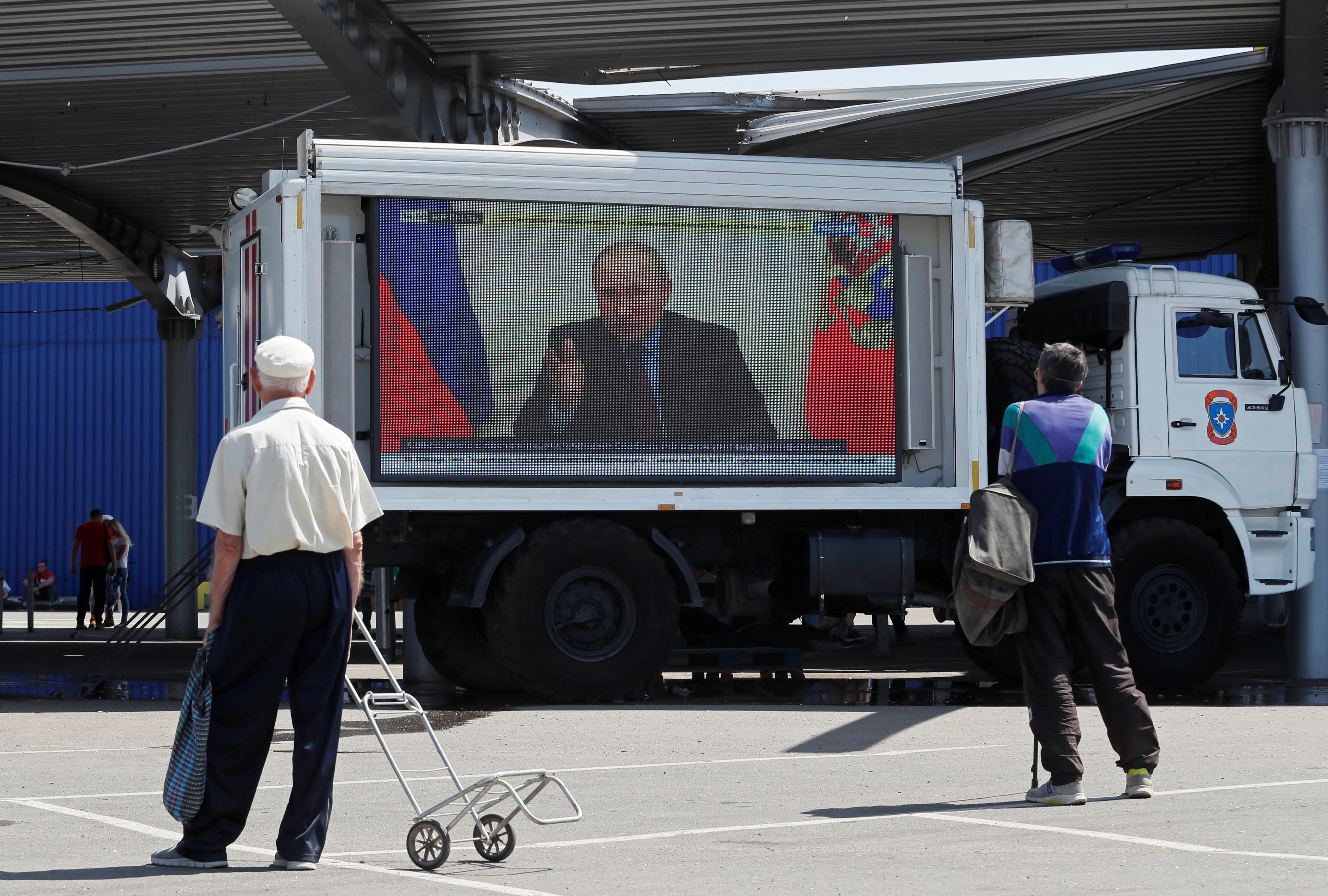Russian President Vladimir Putin is seen on a screen broadcasting Russian TV news programs at a humanitarian aid distribution point during Ukraine-Russia conflict in the southern port city of Mariupol, Ukraine May 30, 2022. REUTERS/Alexander Ermochenko