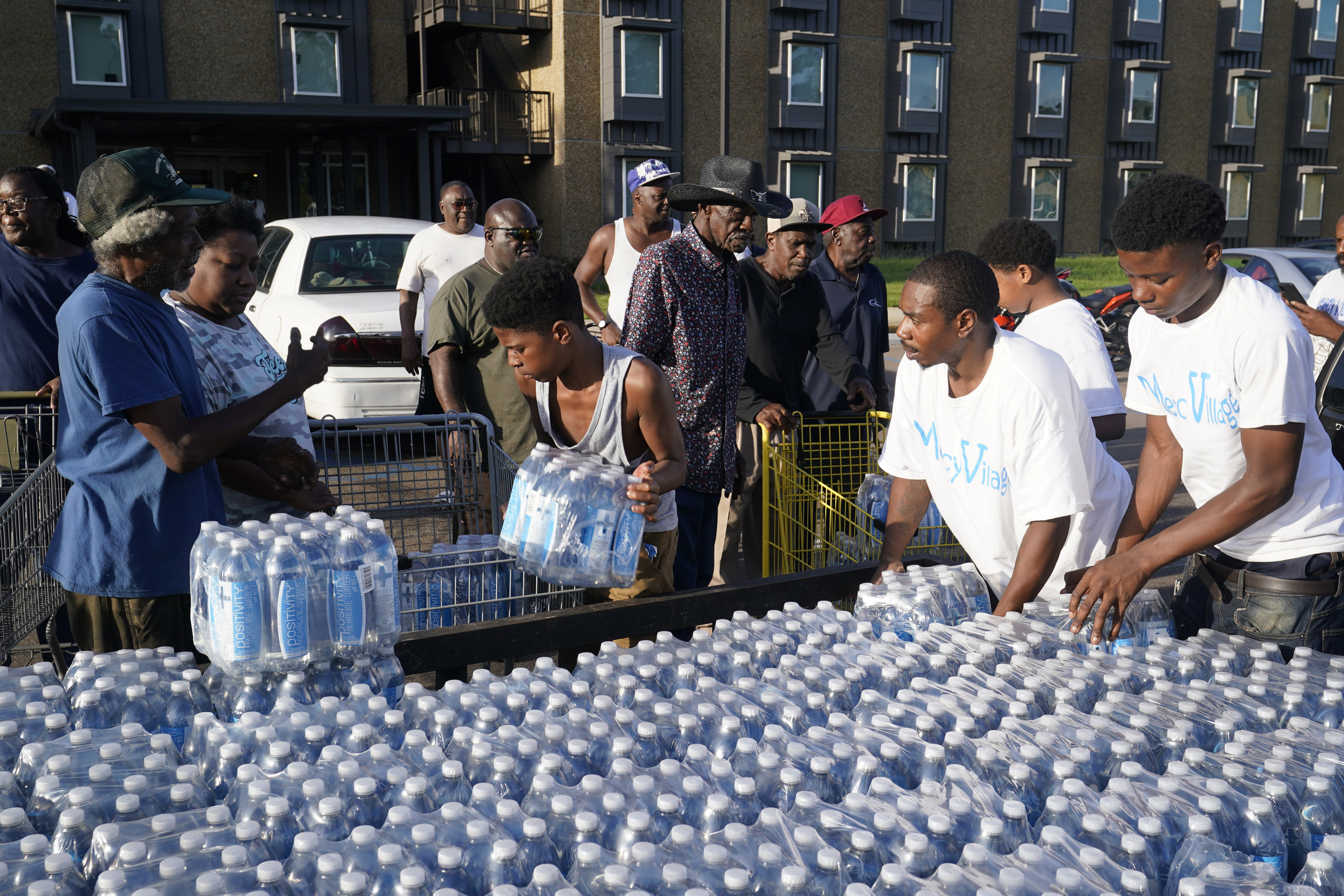 Residents of the Golden Keys Senior Living apartments flocking to a trailer full of water being delivered by the AIDS Healthcare Foundation in Jackson, Mississippi