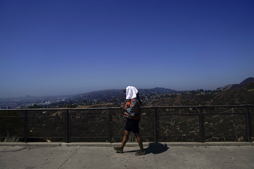 A tourist with a white towel on their head tries to stay cool in Los Angeles, California.