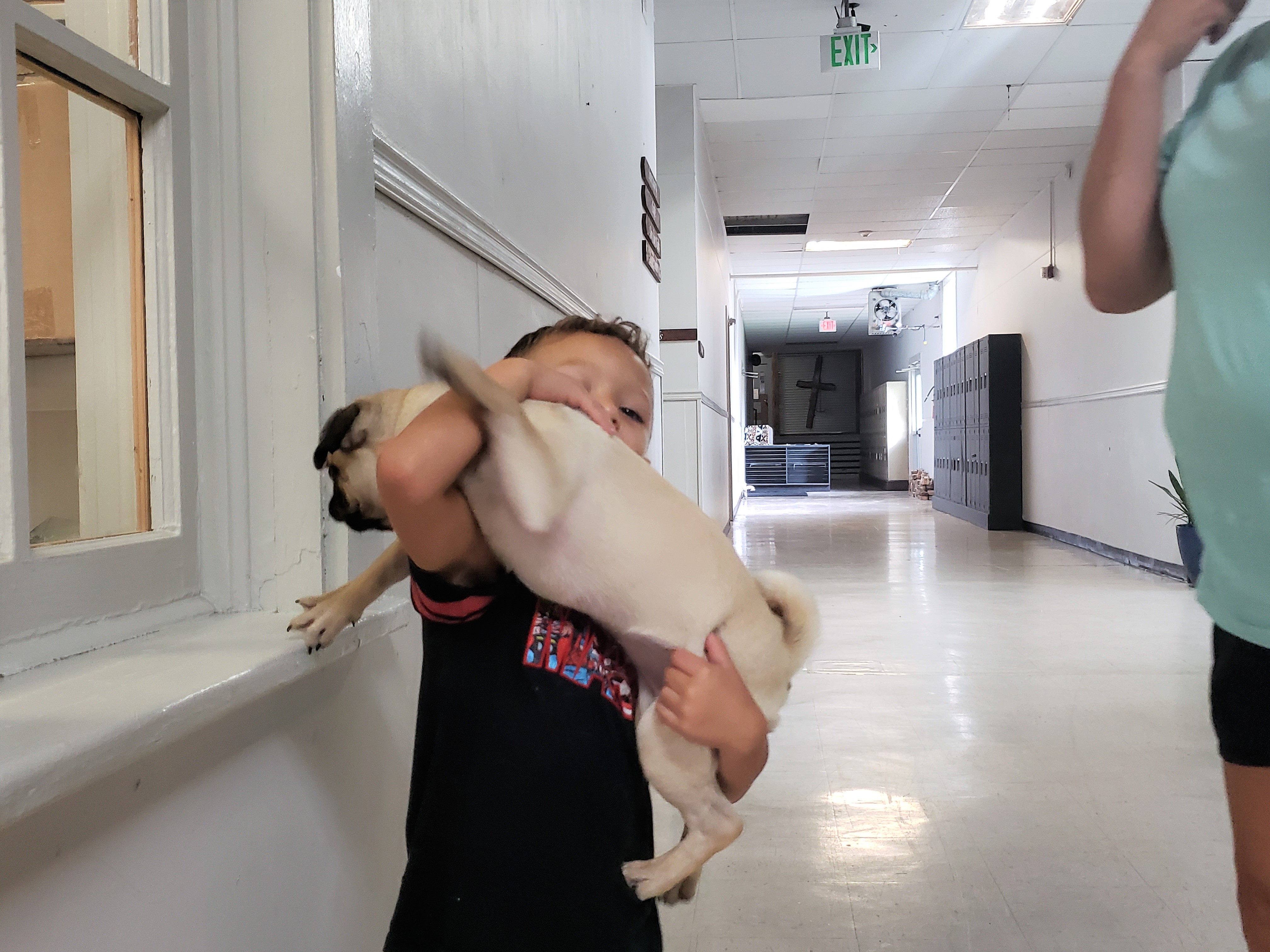 A photo of Josaiah holding Gracie, the pug.