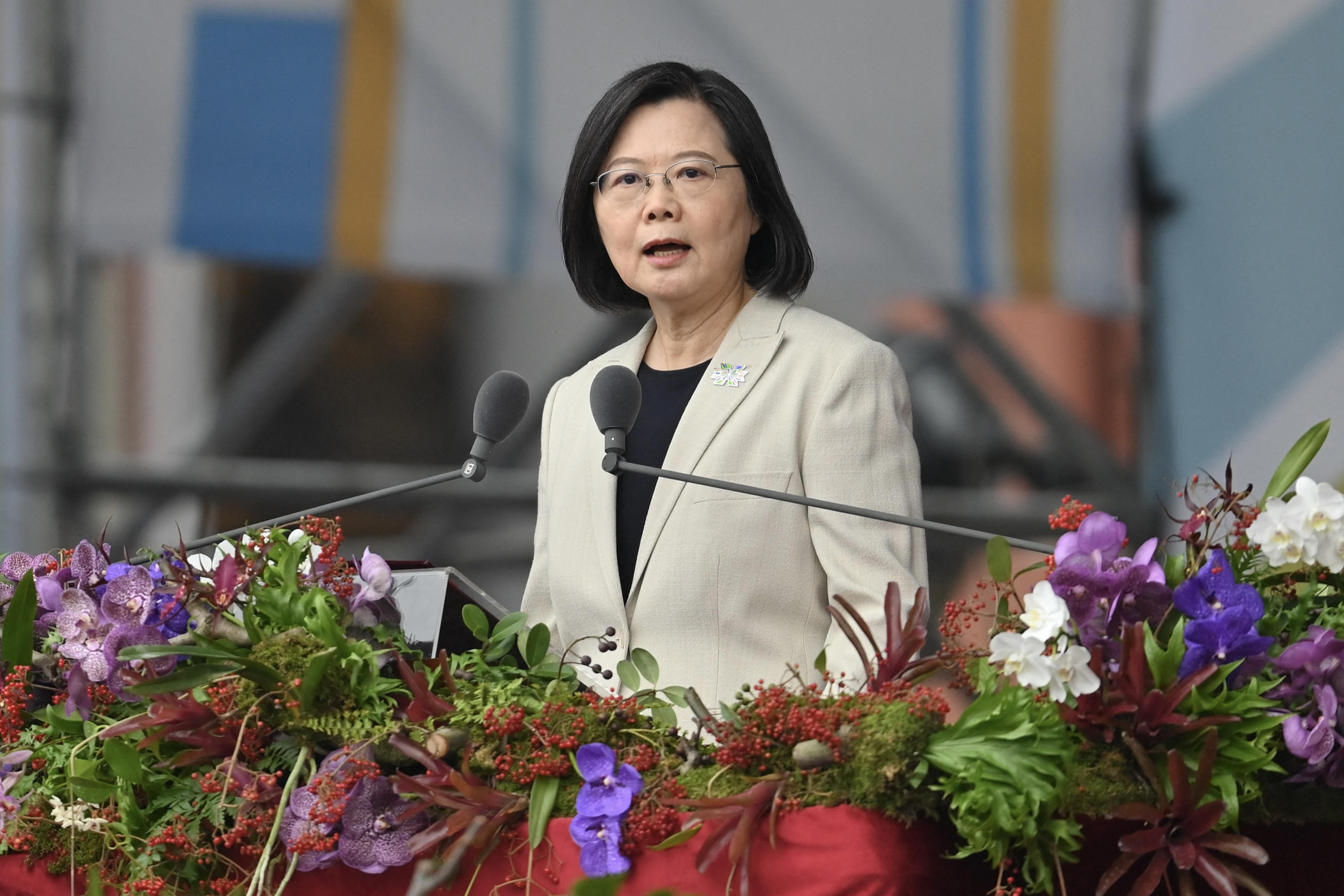 Tsai Ing-wen speaks at a lectern which is decorated with greenery and flowers