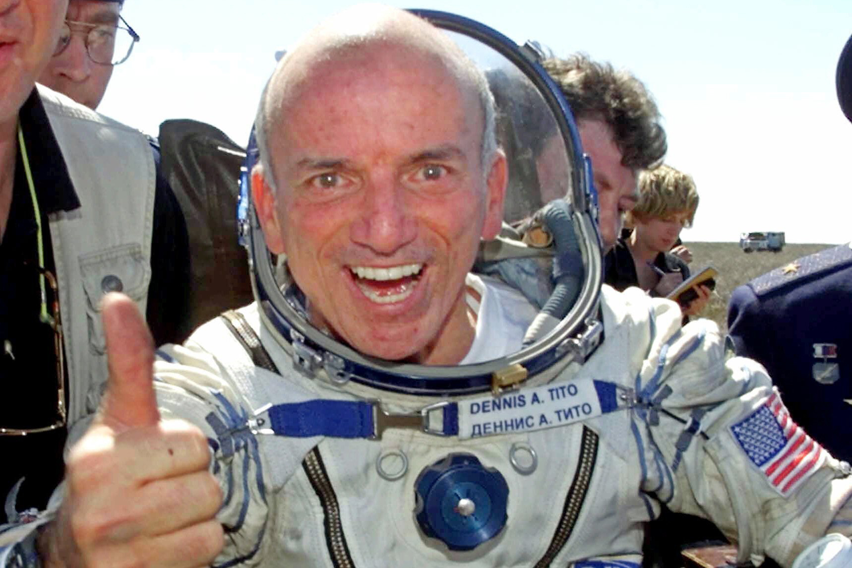 Dennis Tito in a space suit gives a thumbs up after returning to earth from Space in 2001