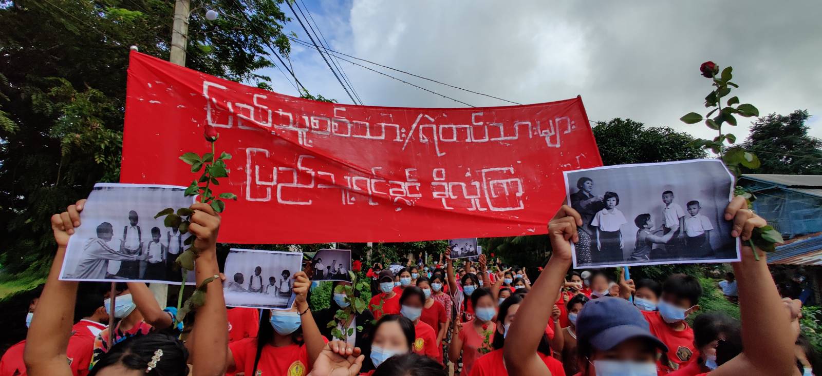Women from the Rosy Women's Union hold a peaceful march holding up black and white photographs of children