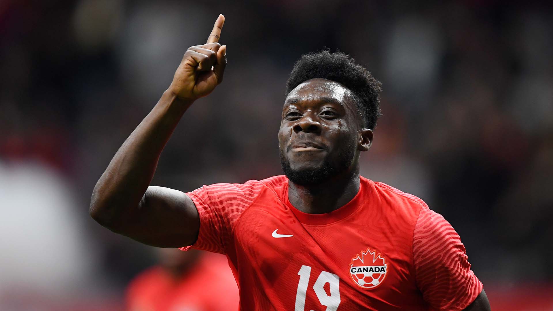 A photo of a football player pointing up.