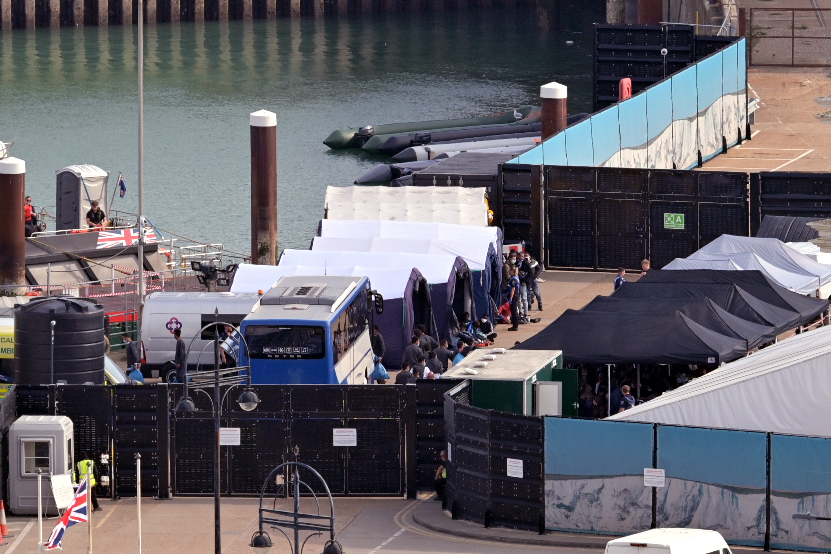 Migrants are processed after disembarking a Border Force vessel carrying migrants rescued in the English Channel, at Dover Dock