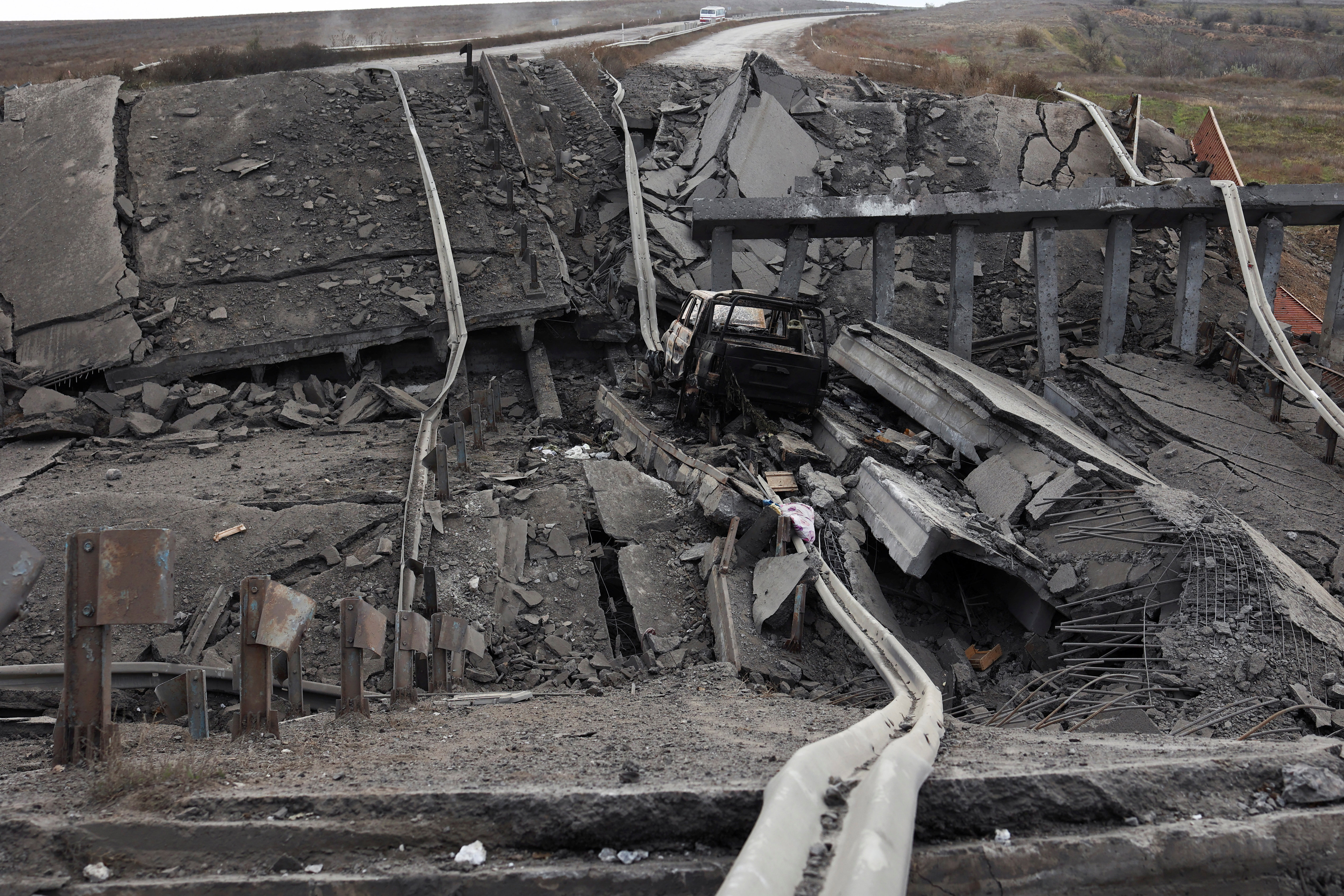 A damaged vehicle is seen on the main road between Kherson and Mykolaiv