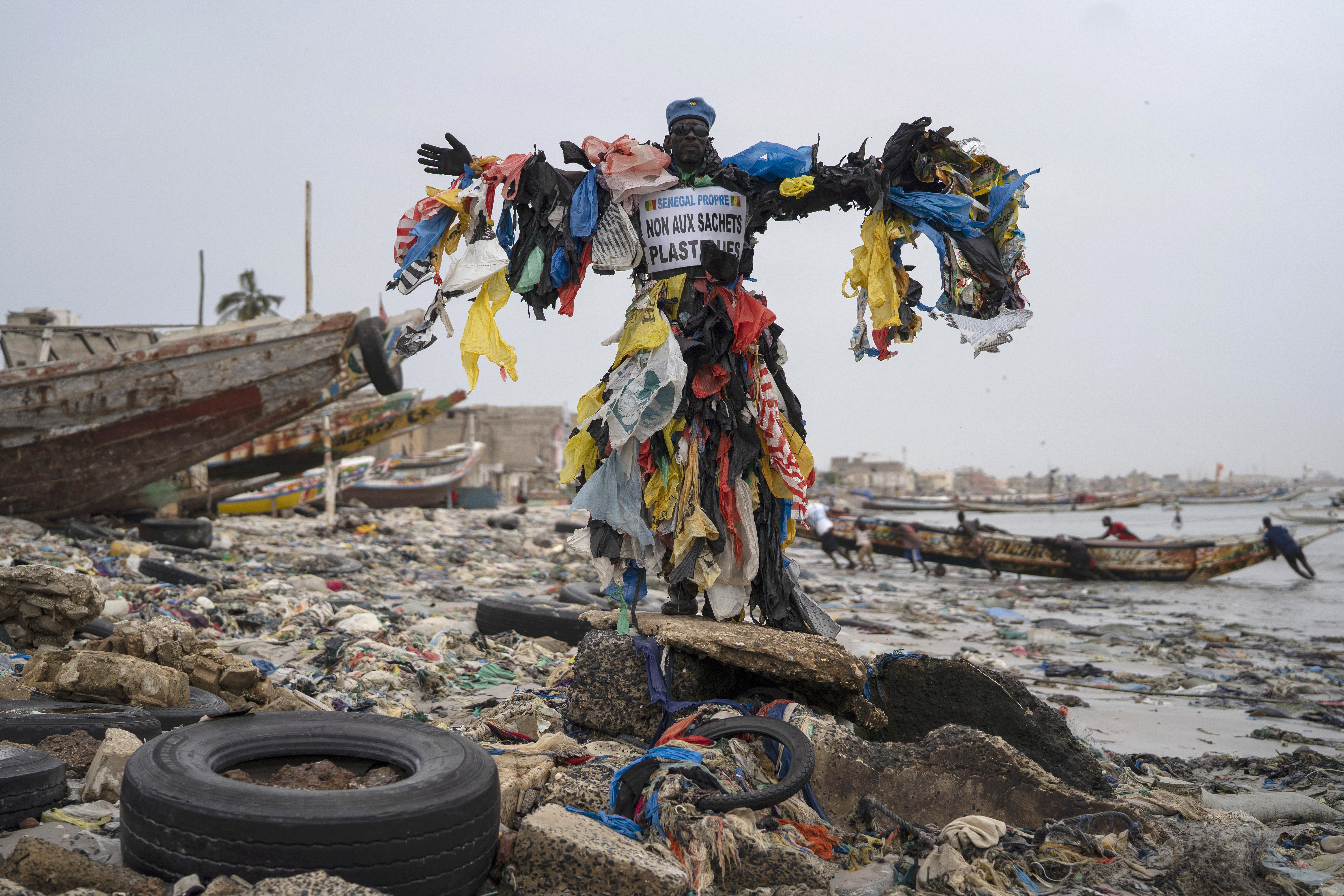 "Plastic Man", poses for a photo at the Yarakh Beach littered by trash and plastics in Dakar, Senegal.