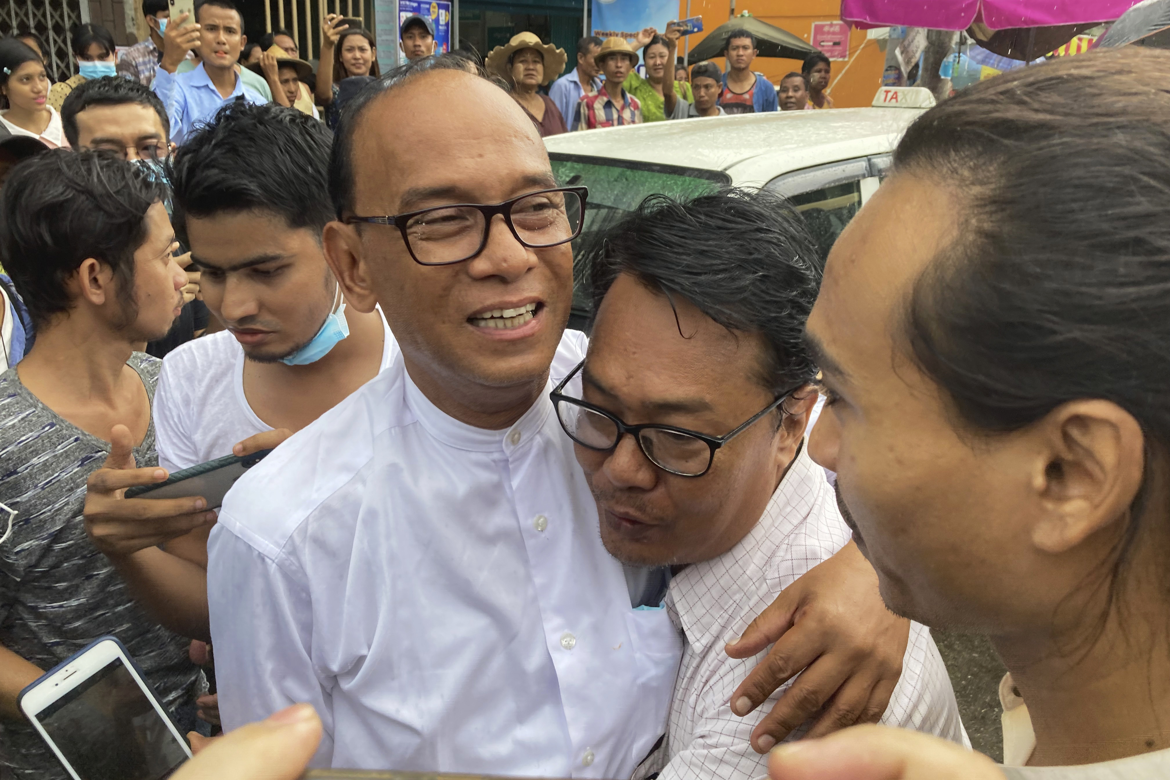 Mya Aye hugging his colleague and smiling as he is released from prison. Everyone else looks happy too