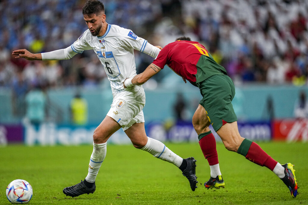 Uruguay's Rodrigo Bentancur fights for the ball with Portugal's Joao Palhinha during their World Cup group H football match.