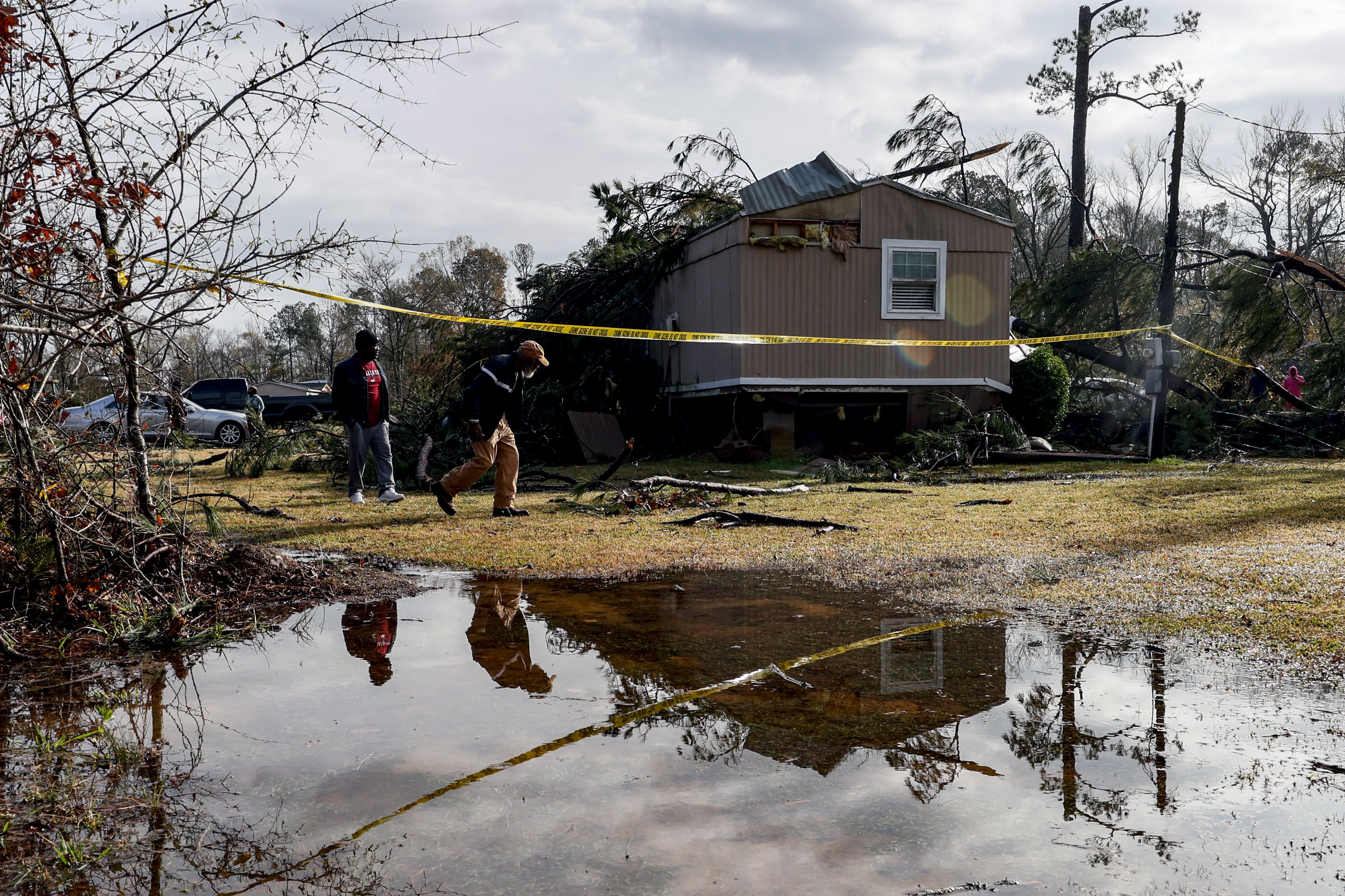 Friends and family survey damage to a house from a possible tornado Wednesday