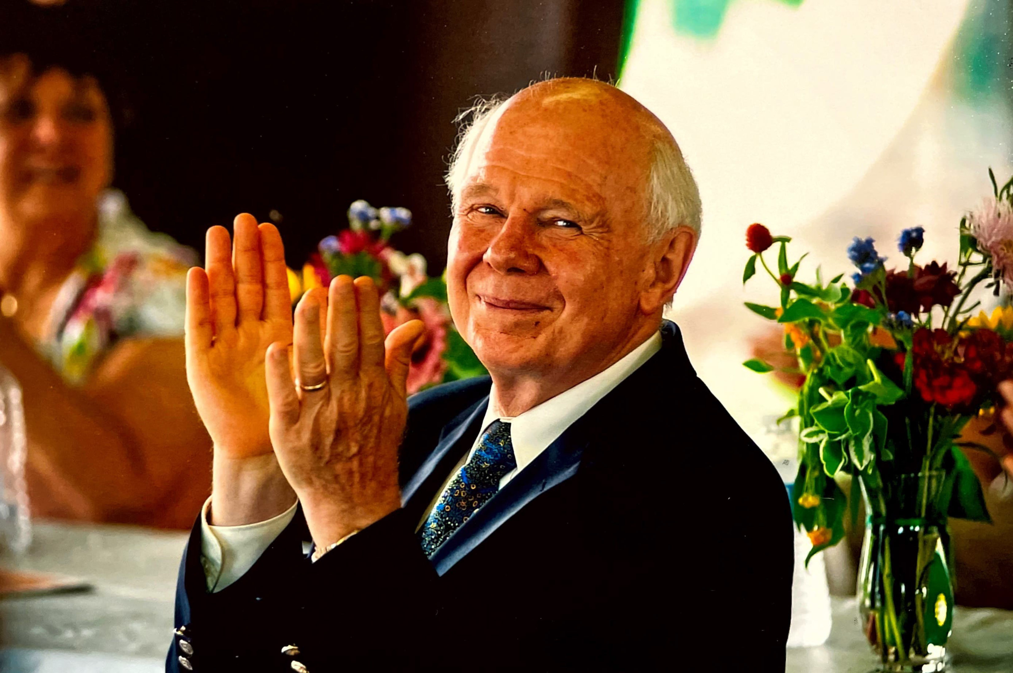 A photo of someone clapping and smiling.