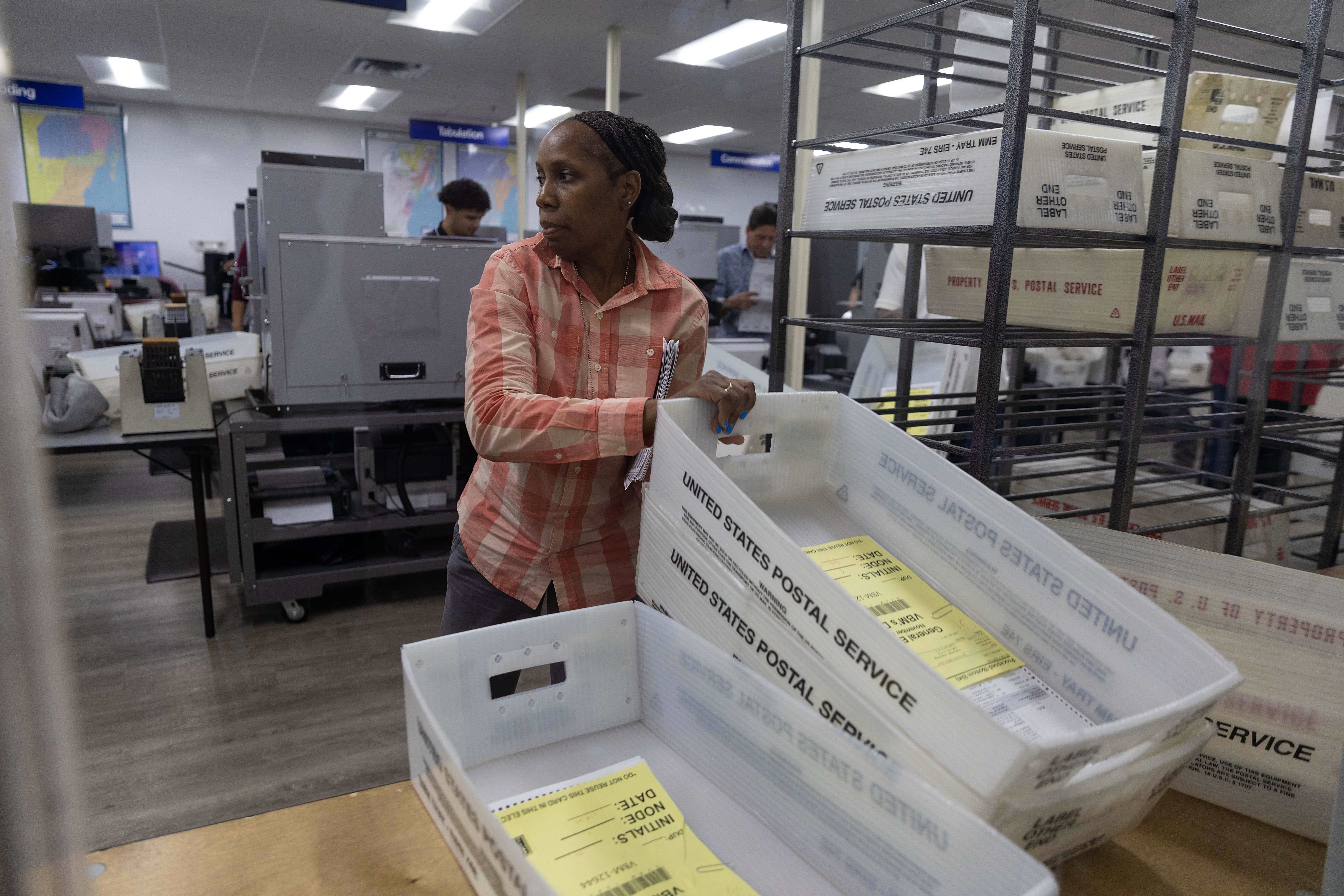 Employees of the Miami Dade County of elections department begin counting mail in ballot.