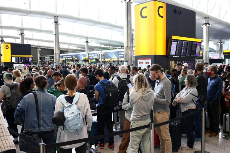 Passengers queue inside the departures terminal of Terminal 2 at Heathrow Airport in London