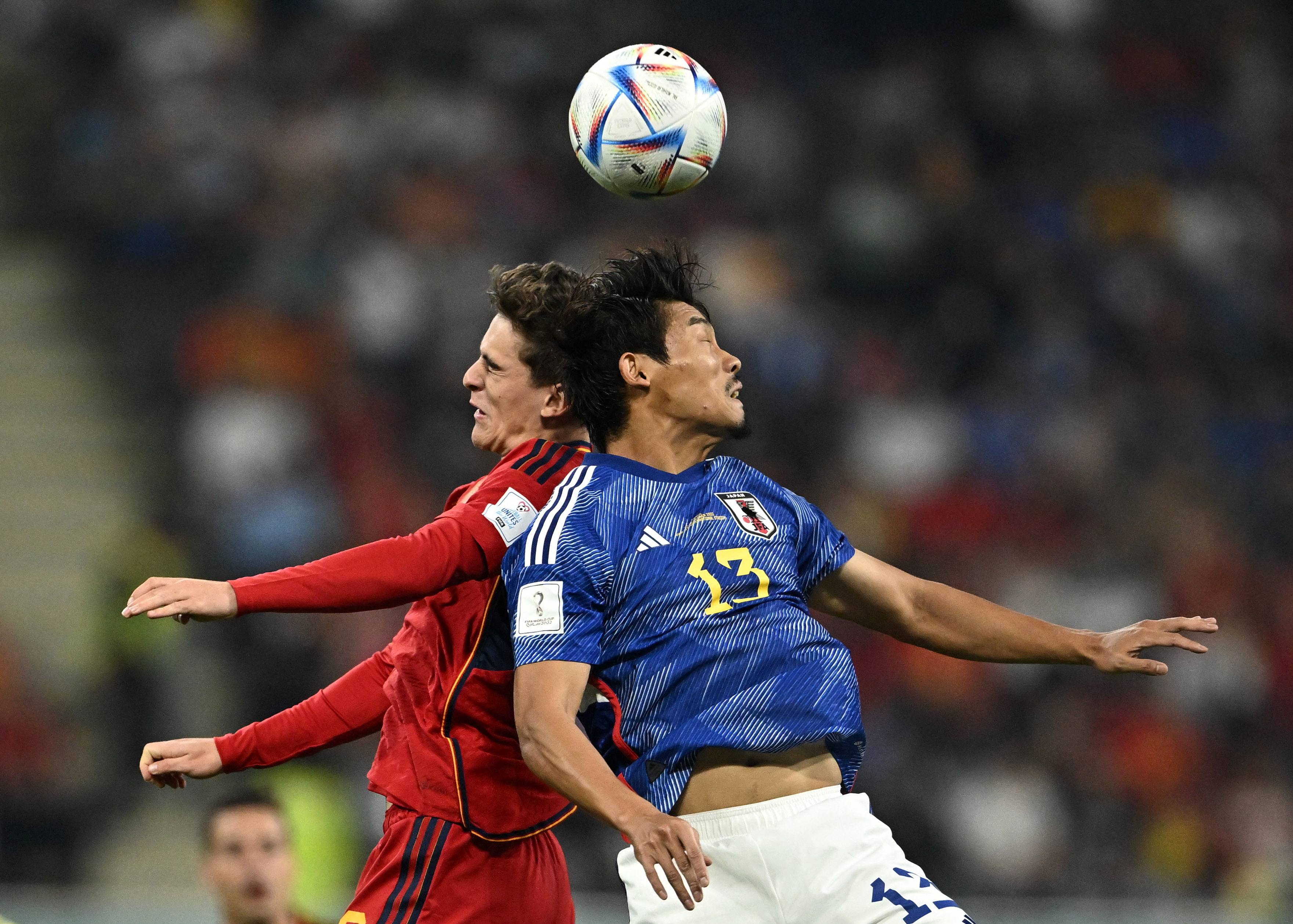 Morita and Gavi come back to back during play with the ball looking like it's hovering above their heads