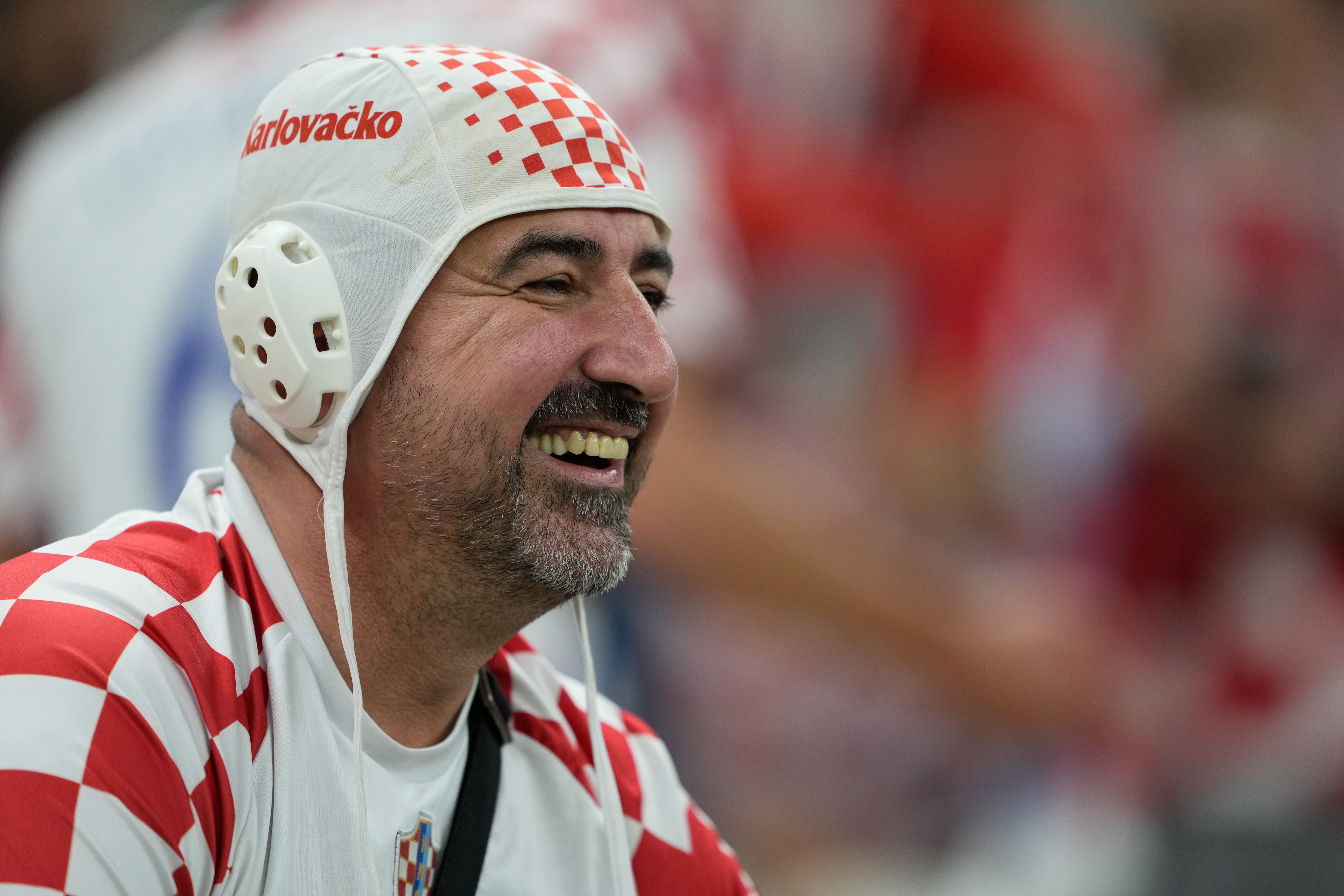 A Croatia fan is smiling in the stands before the match.