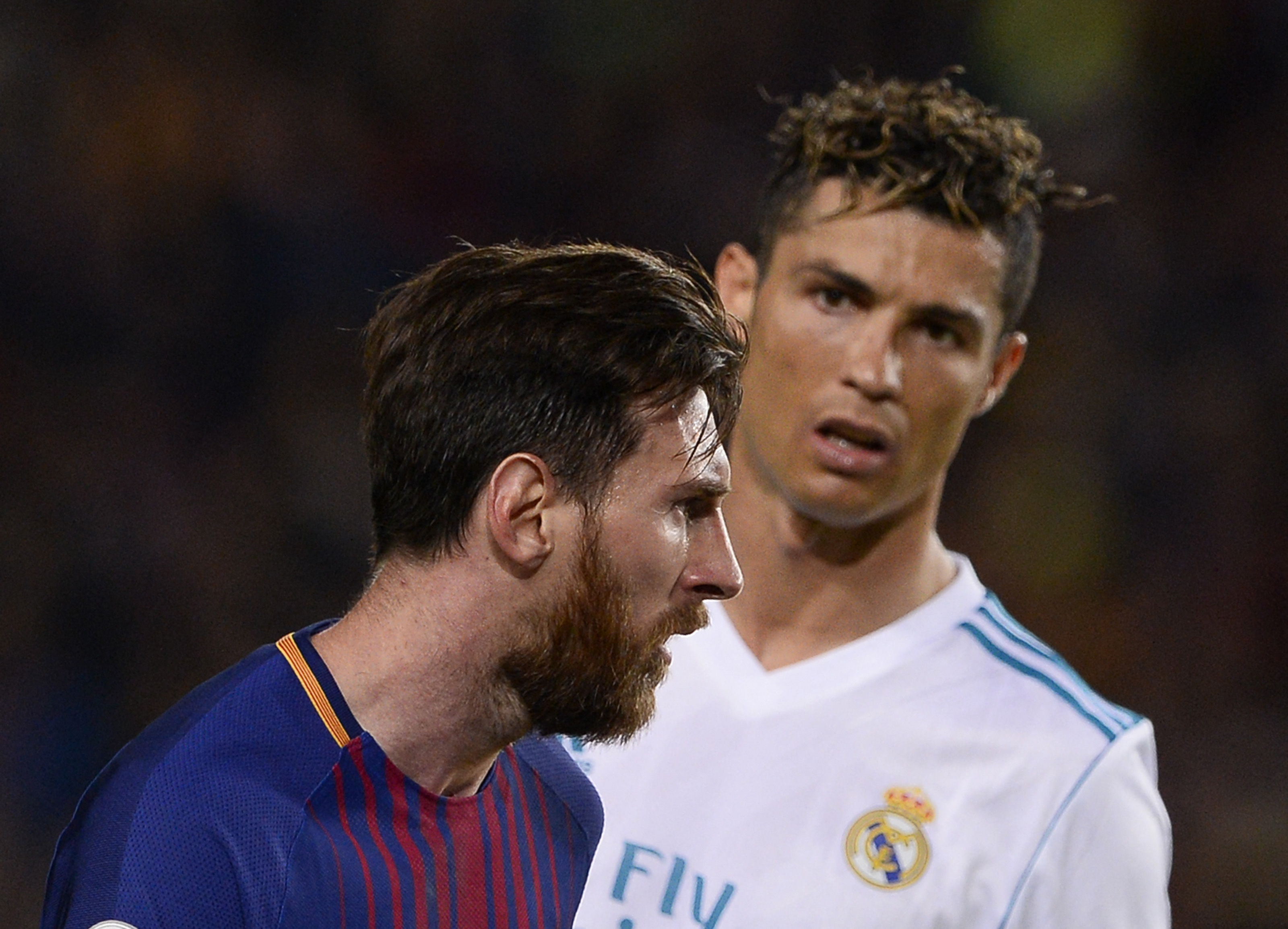 Real Madrid's Portuguese forward Cristiano Ronaldo (R) looks at Barcelona's Argentinian forward Lionel Messi during the Spanish league football match between FC Barcelona and Real Madrid CF at the Camp Nou stadium in Barcelona on May 6, 2018.