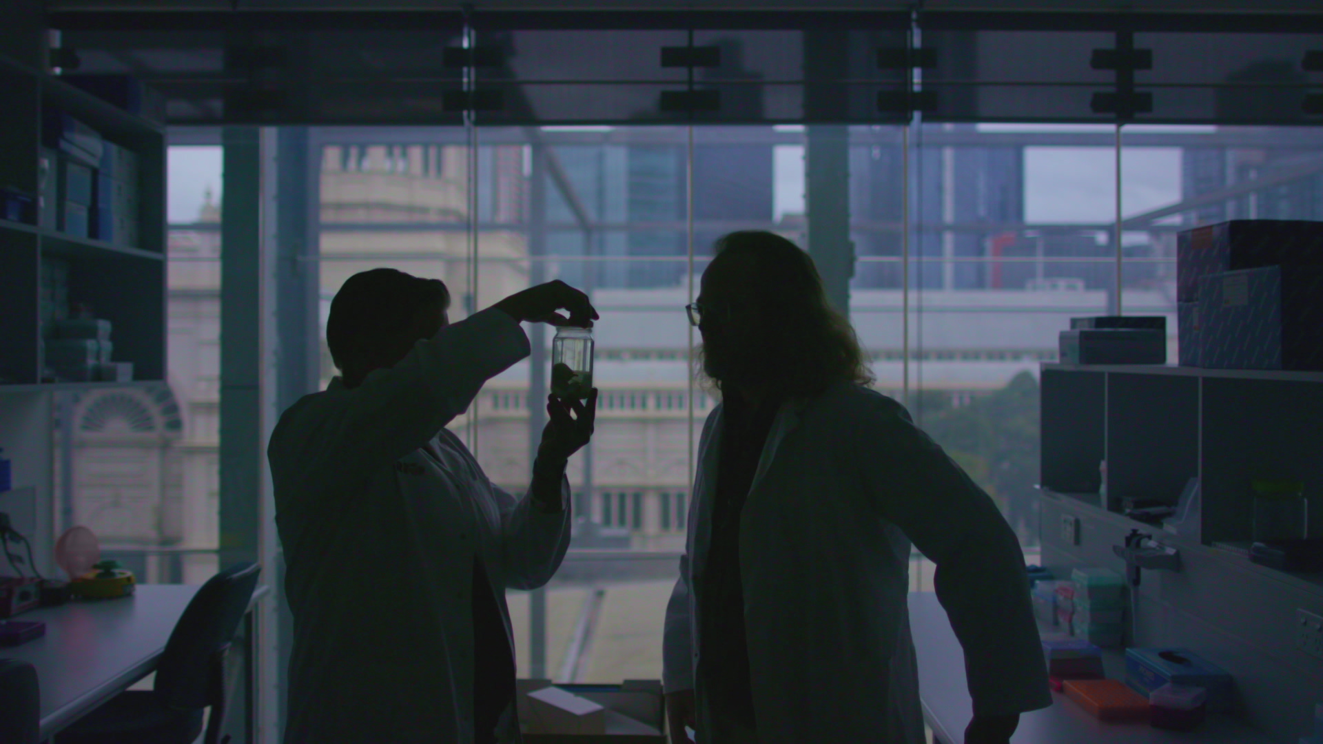 A photo of Dr Andrew Pask and Dr Kevin Rowe inspecting a jar with a preserved Thylacine pouch young.