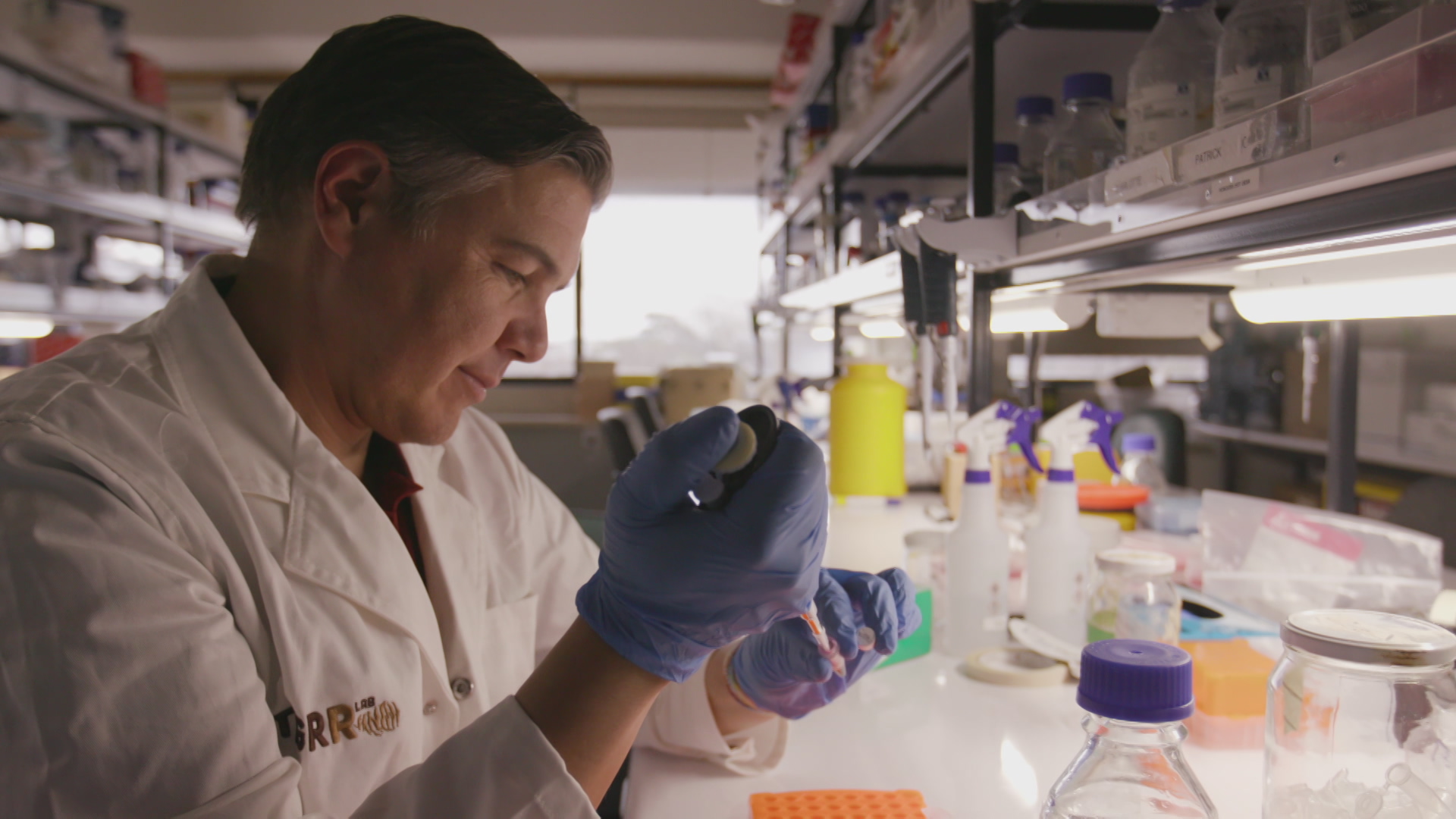 A photo of Dr Andrew Pask in a lab pipetting something.