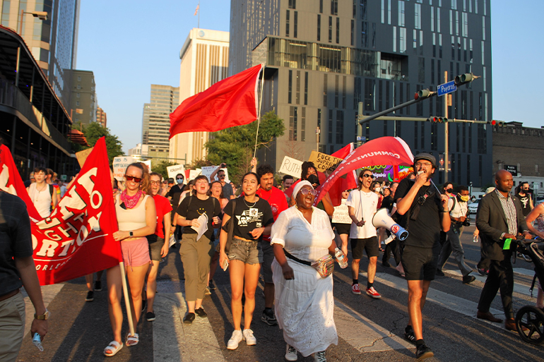 A photo of a group of people walking in the street in a protest for abortion rights.