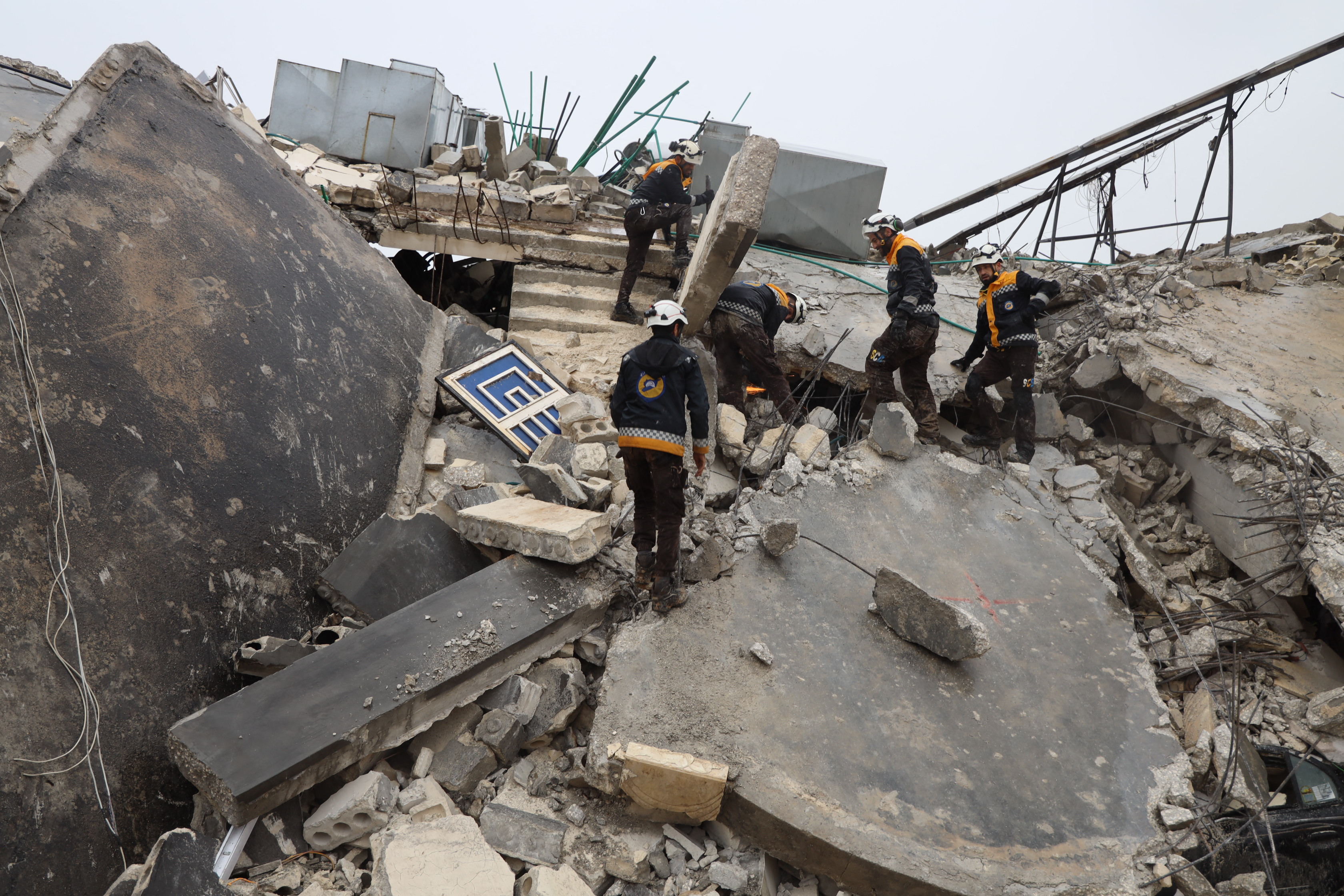 Members of the Syrian civil defence, known as the White Helmets transport a casualty pulled from the rubble following an earthquake.