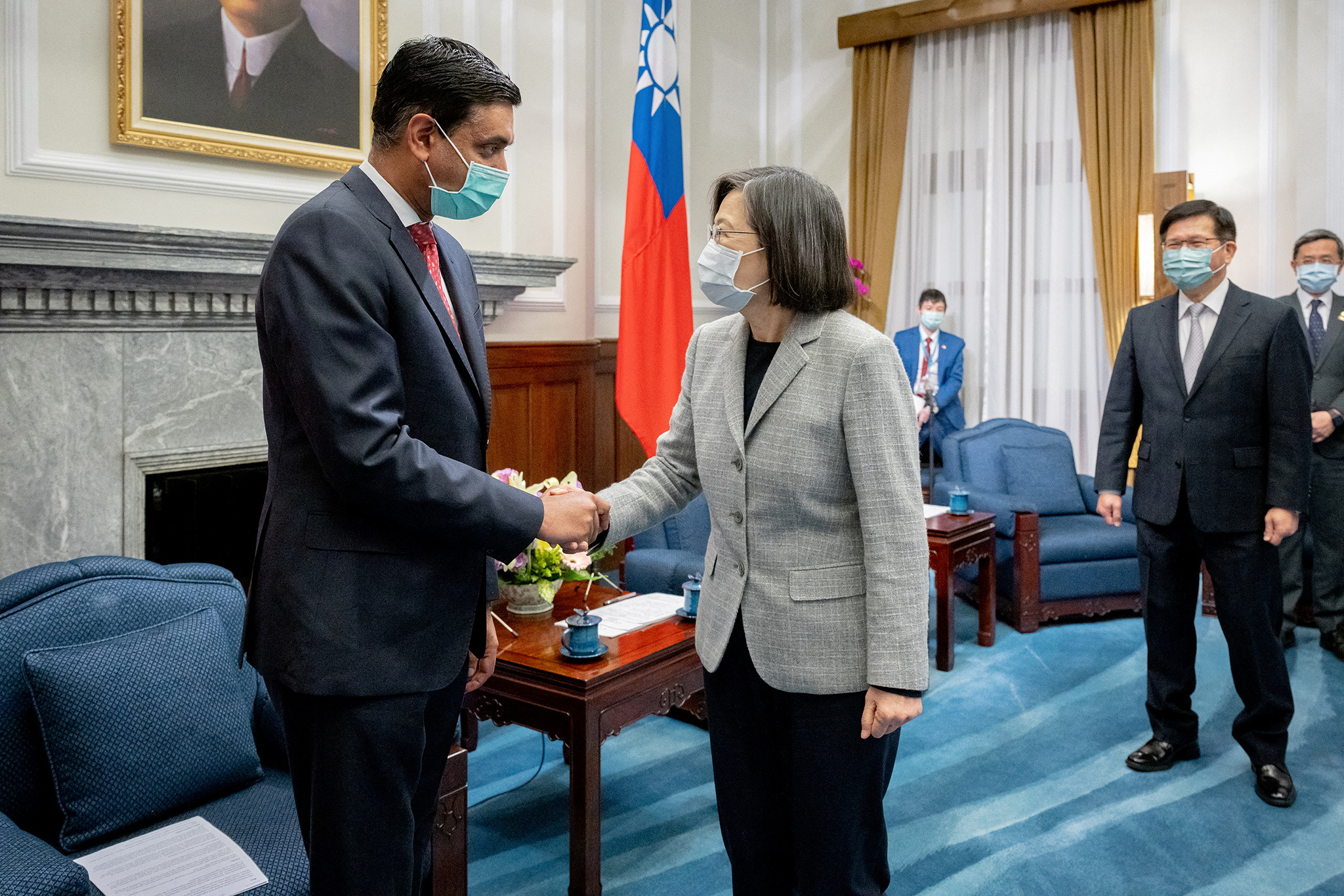 Taiwan President Tsai Ing-wen shakes hands with US lawmaker Ron Khanna. They are in her office and there's a Taiwan flag behind.