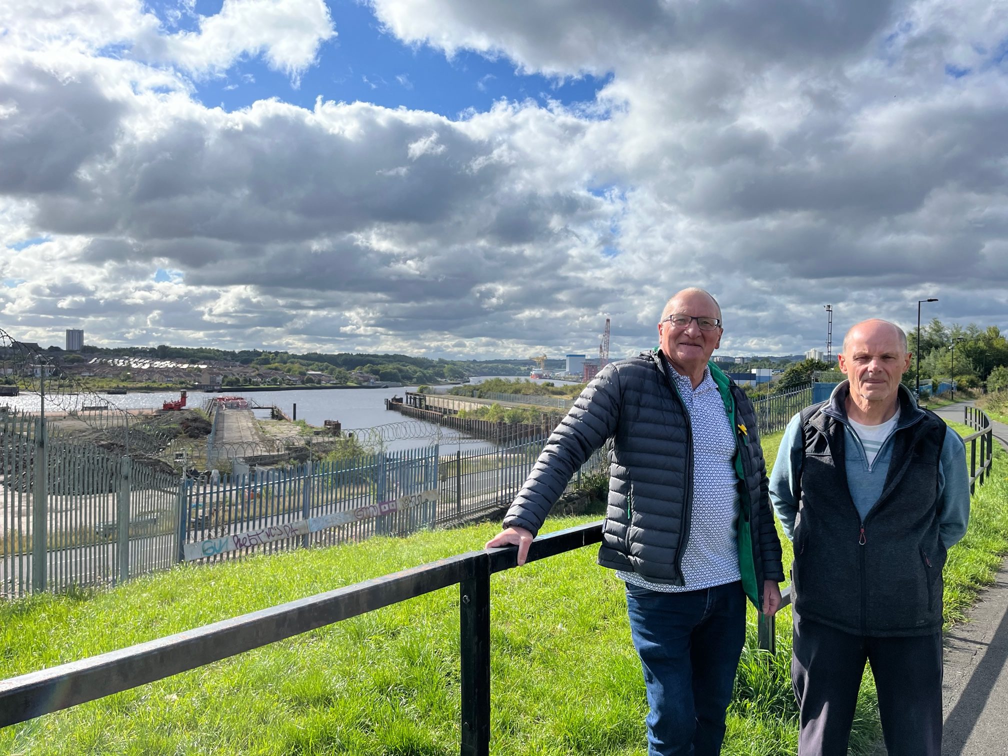 Two men walk near a ship yard in England