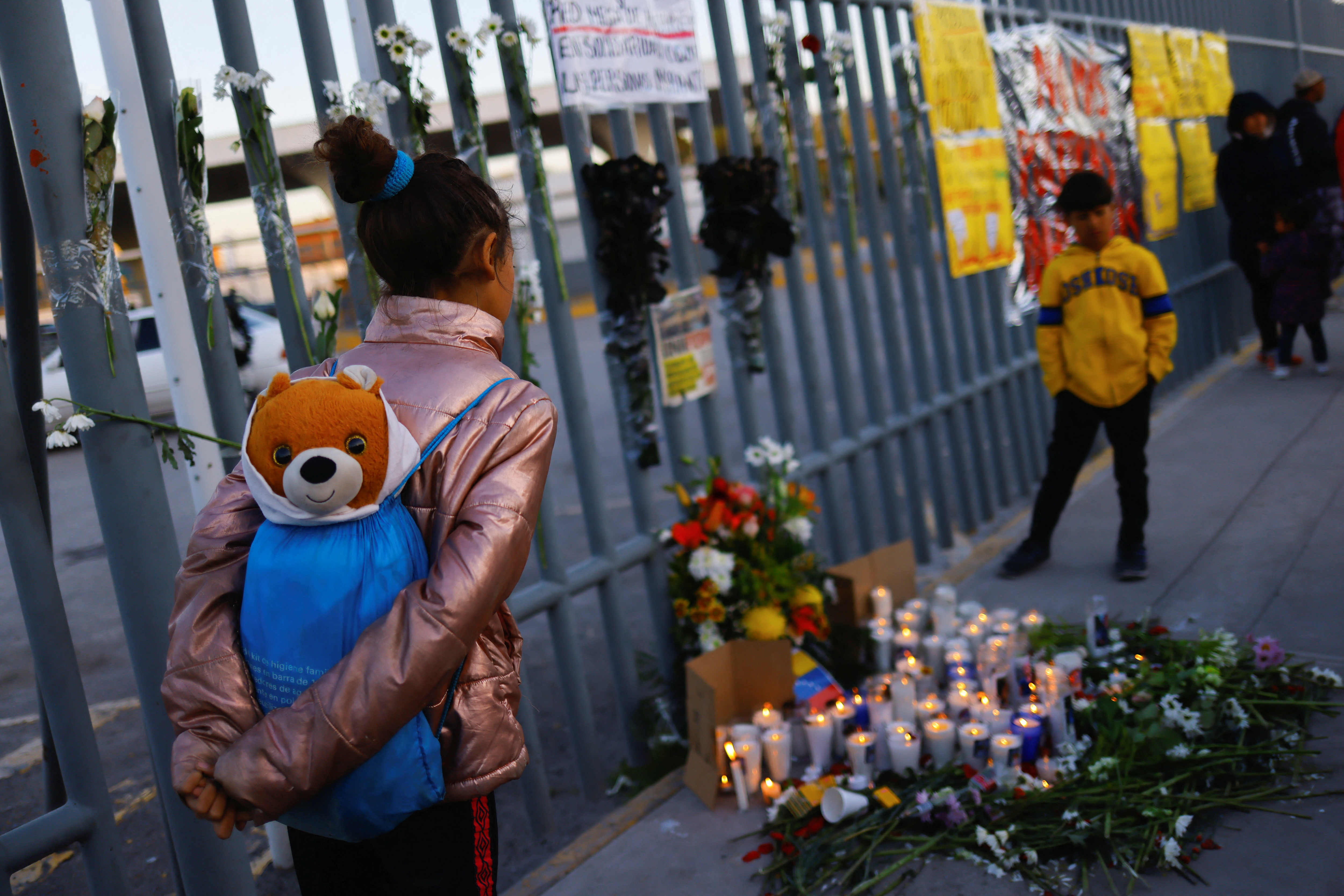 A girl from Venezuela takes part in a vigil outside the detention centre where dozens of migrants were killed in a fire in Ciudad Juarez, Mexico
