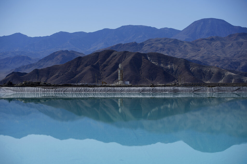 Mountains are reflected in a brine evaporation pond