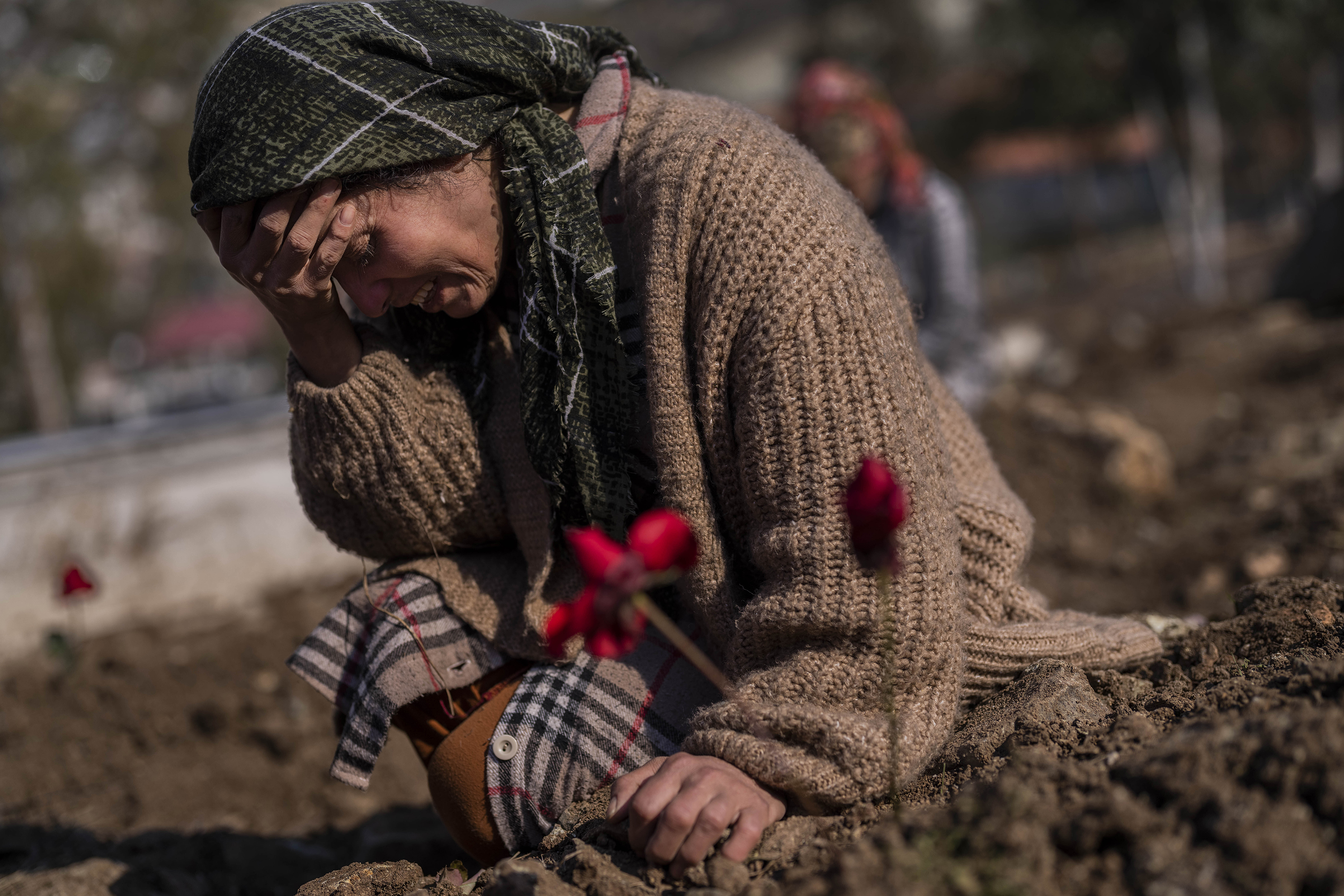 A member of the Vehibe family mourns a relative during the burial of one of the earthquake victims