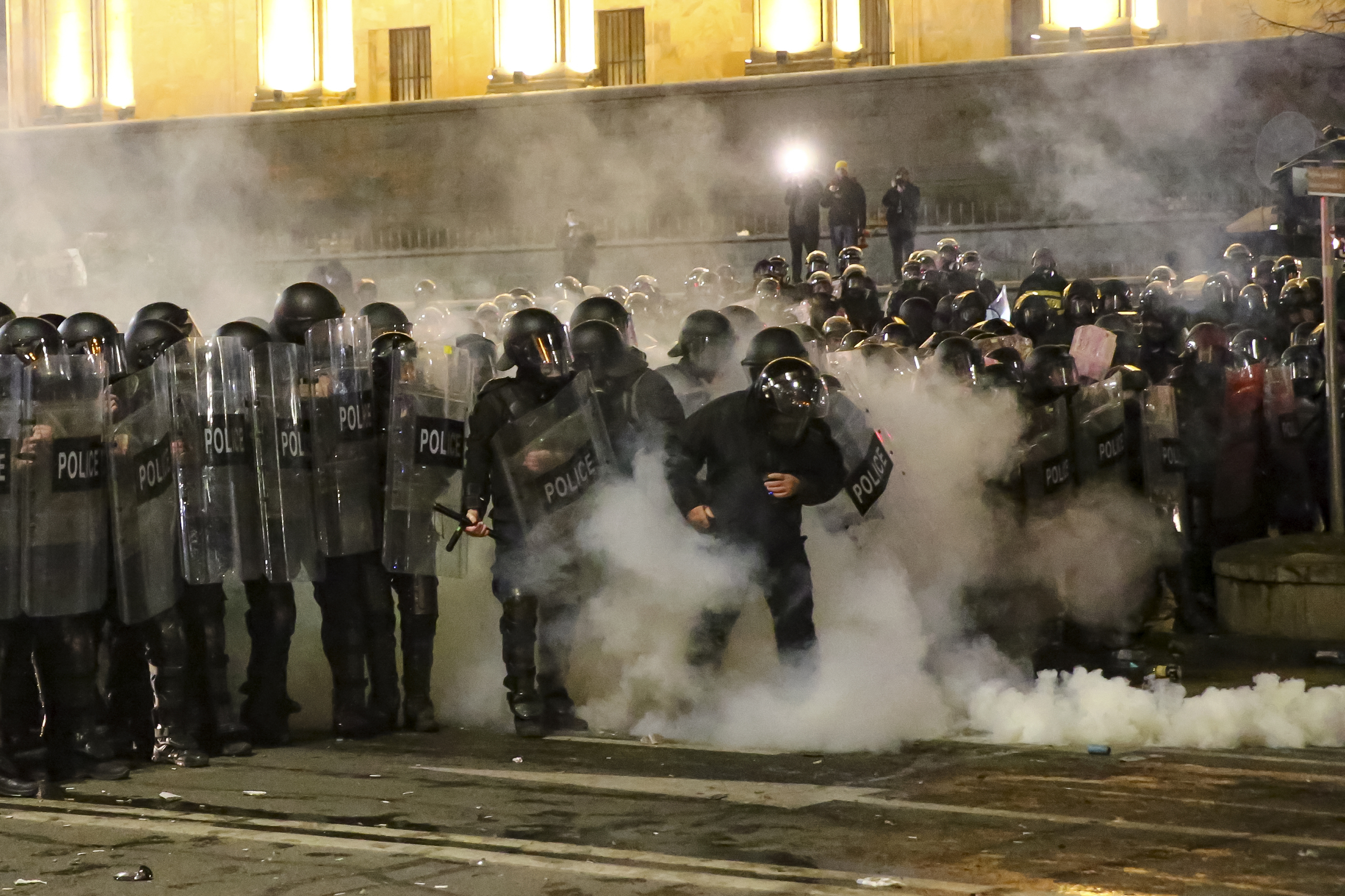 Riot police block a street to stop protesters outside the Georgian parliament building in Tbilisi, Georgia, early Thursday, March 9, 2023