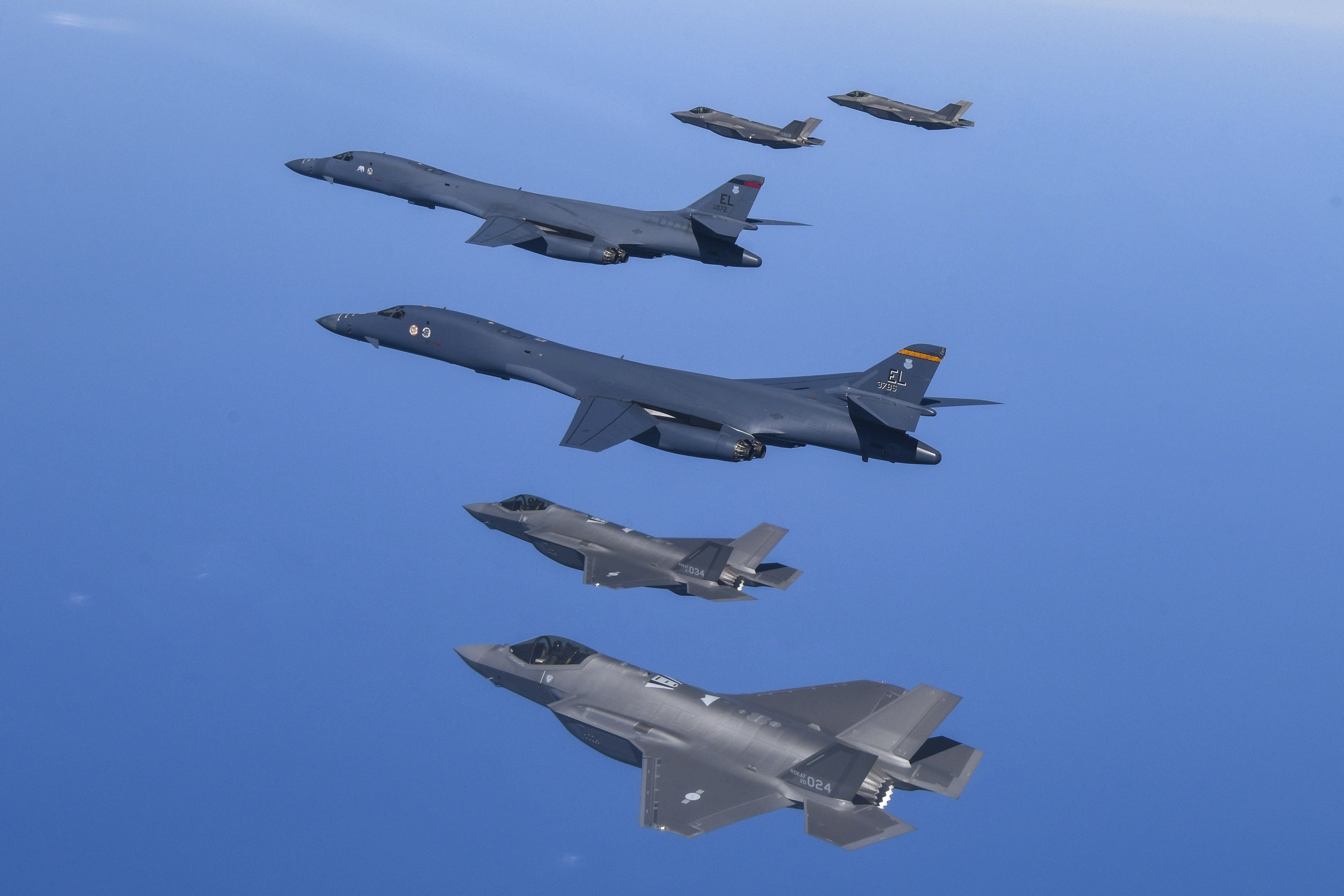 .S. Air Force B-1B bombers, center, fly in formation with South Korea's Air Force F-35A fighter jets 
