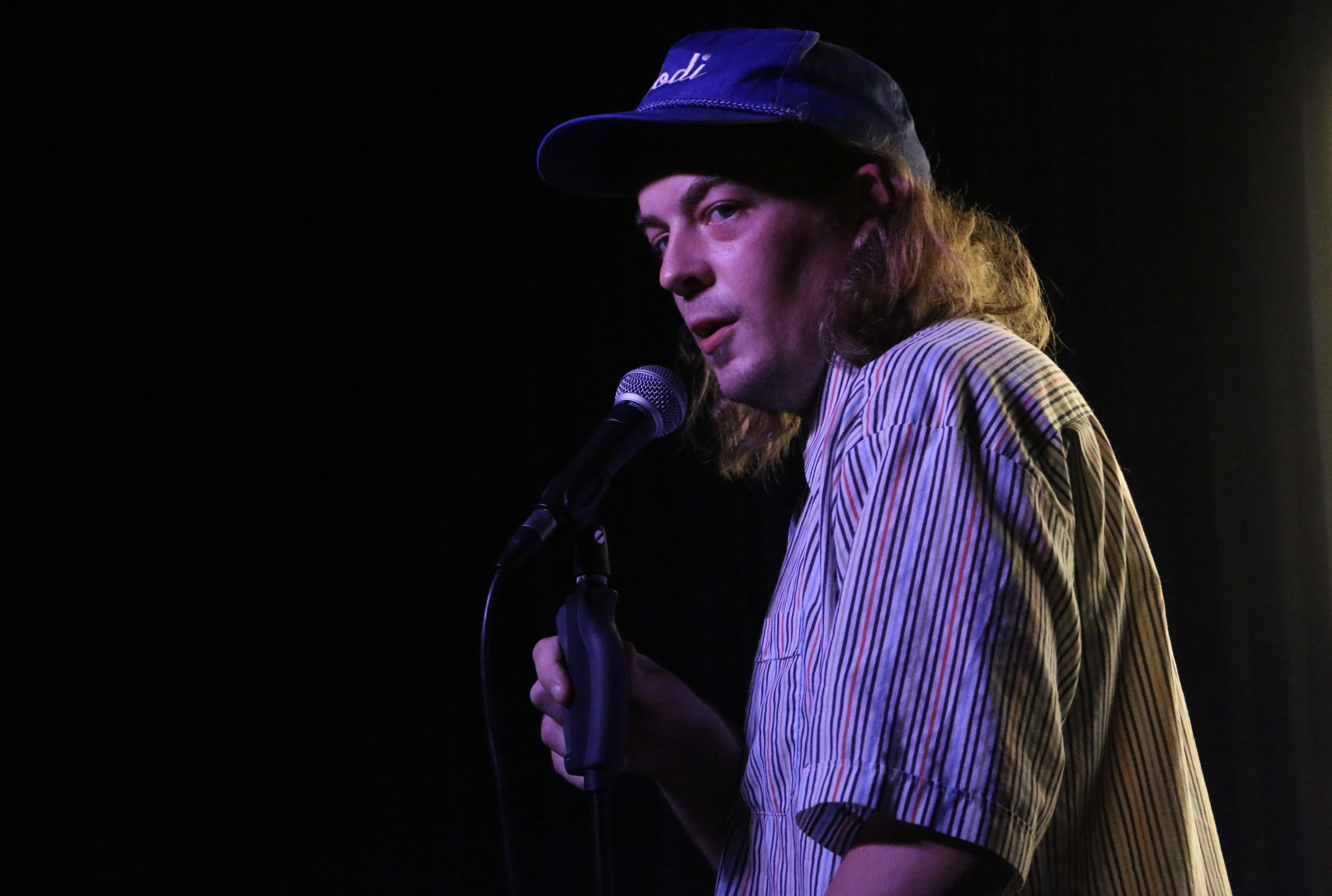 A photo of Kolya performing at a comedy club.