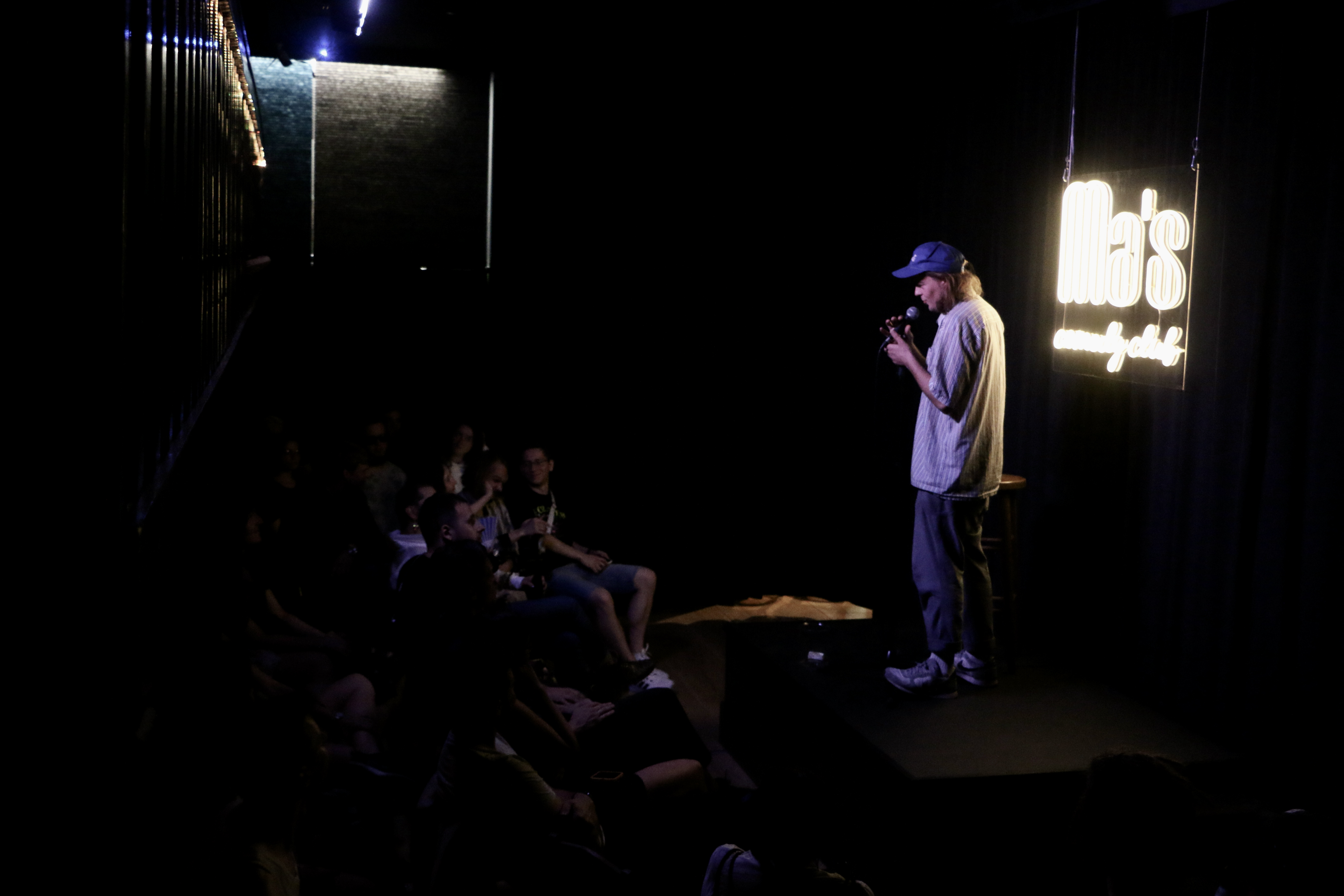 A photo of Kolya performing at a comedy club.