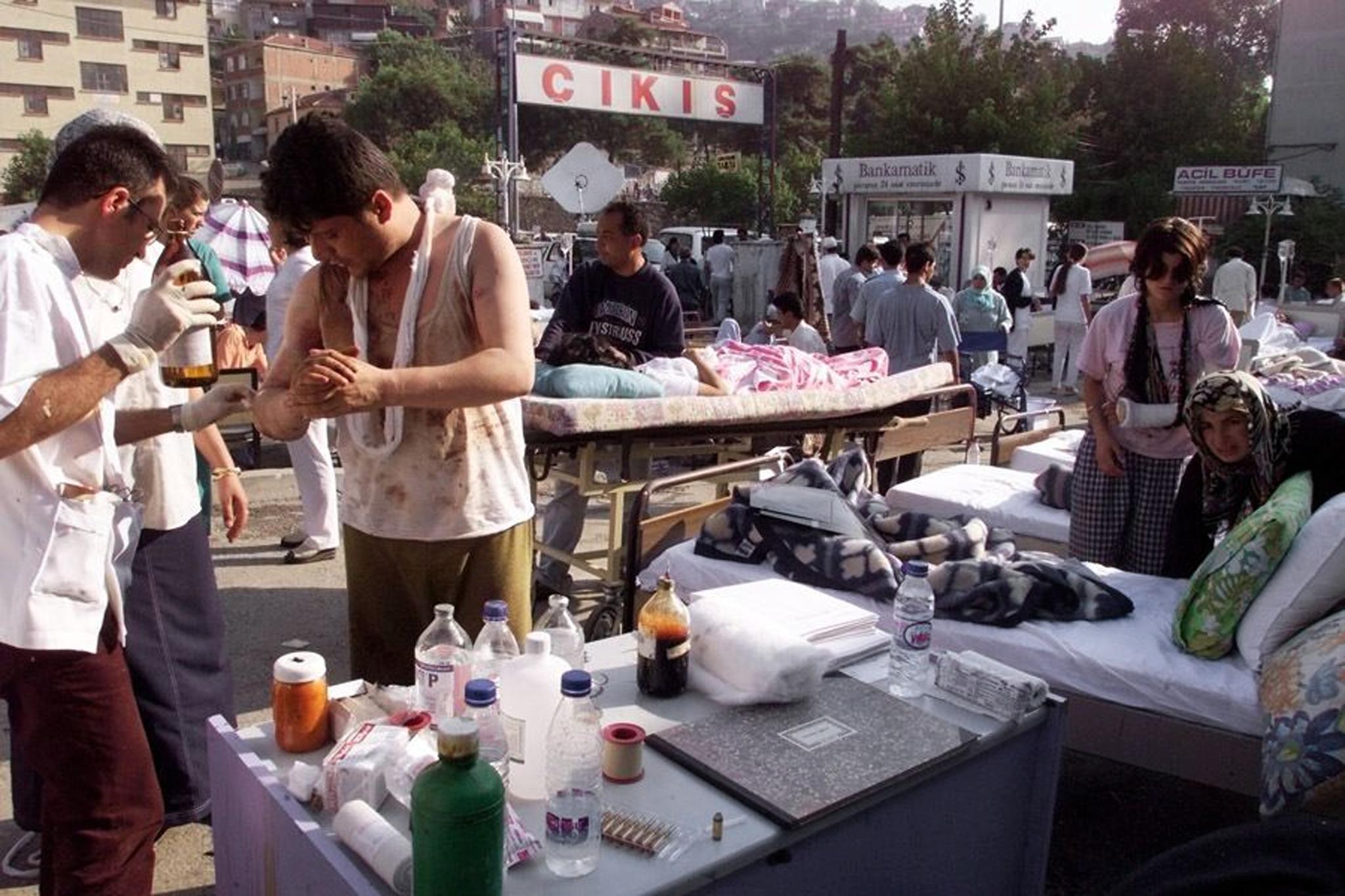 Injured people are treated 18 August 1999 in the courtyard of a hospital in Izmit, 150 kms east of Istanbul on the Marmara Sea, where the death toll rose to at least 2,000 following the 17 August 1999 earthquake, measuring 7.4 on the open-ended Richter scale. The Turkish government crisis center counted 18 August 1999 3,839 dead and more than 19,000 injured in the central and western Anatolian provinces.   (ELECTRONIC IMAGE) (Photo by PIERRE VERDY / AFP)