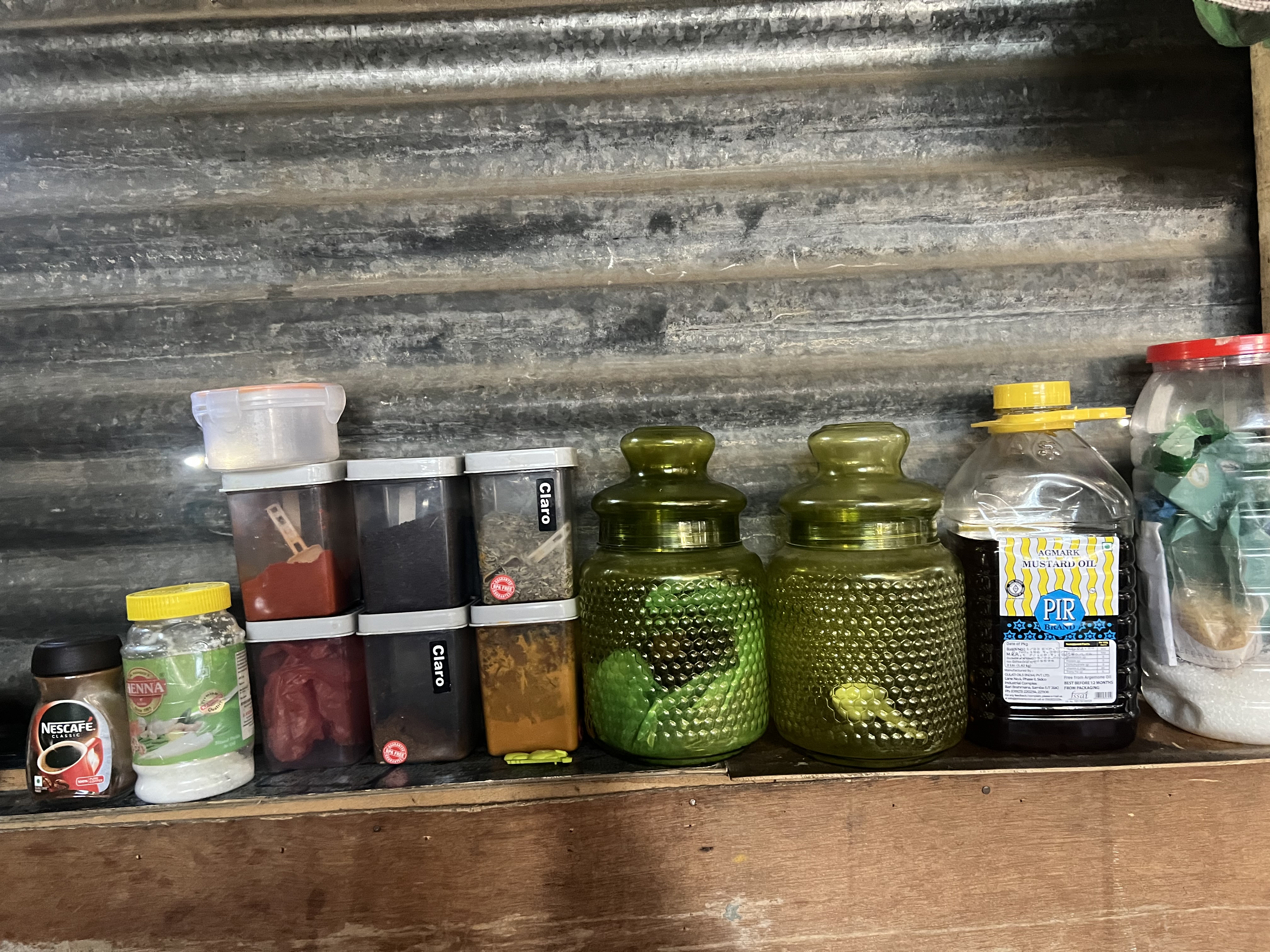 A photo of a row of herbs and spices, coffee, and a variety of other jars.