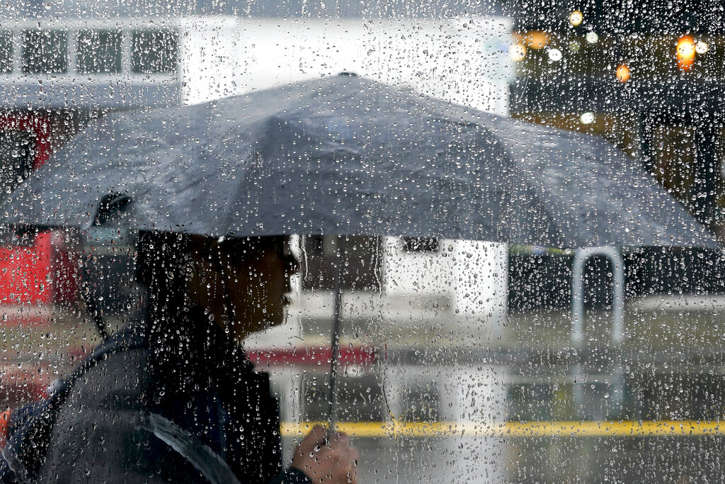 A person uses an umbrella to avoid the rain in California