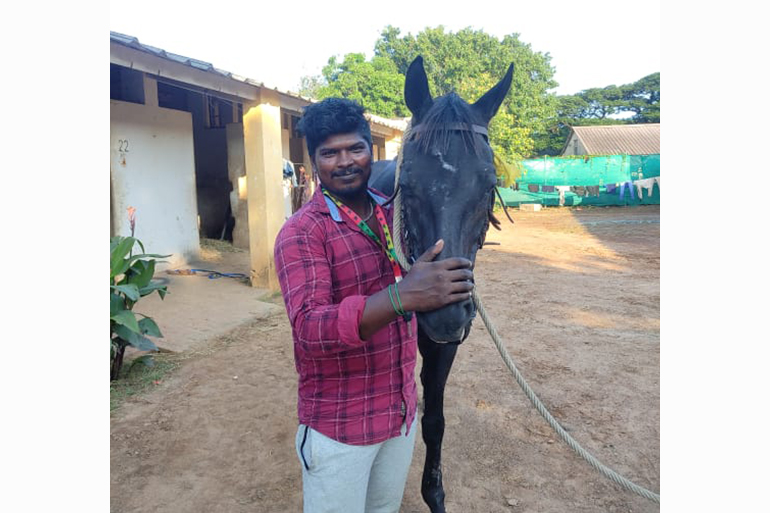 A man standing next to a horse.
