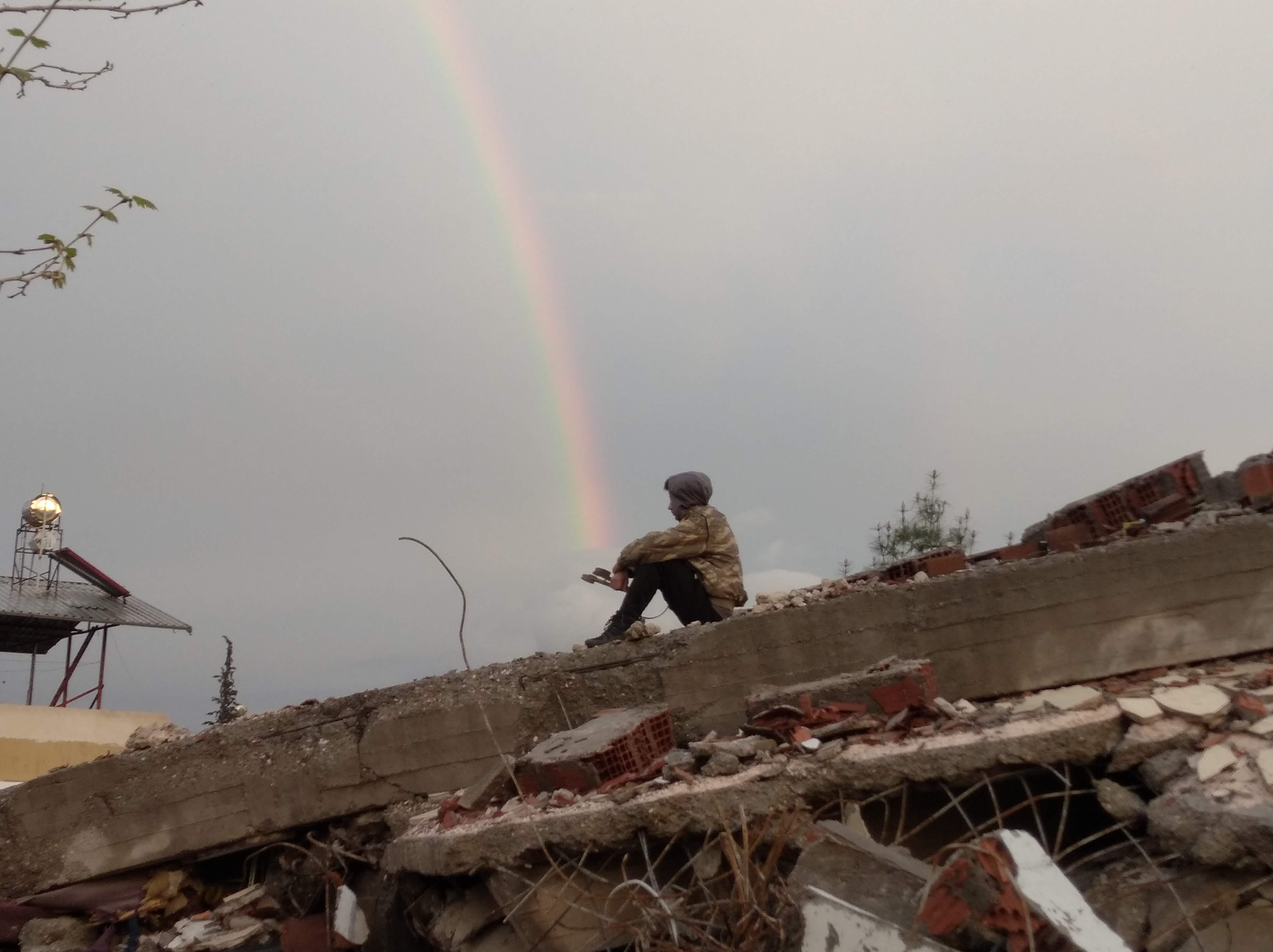Yusuf Kahriman, Sevim's 15-year old son, takes a break from his hiking on the rubble of his neighbor's house in Altınüzüm.