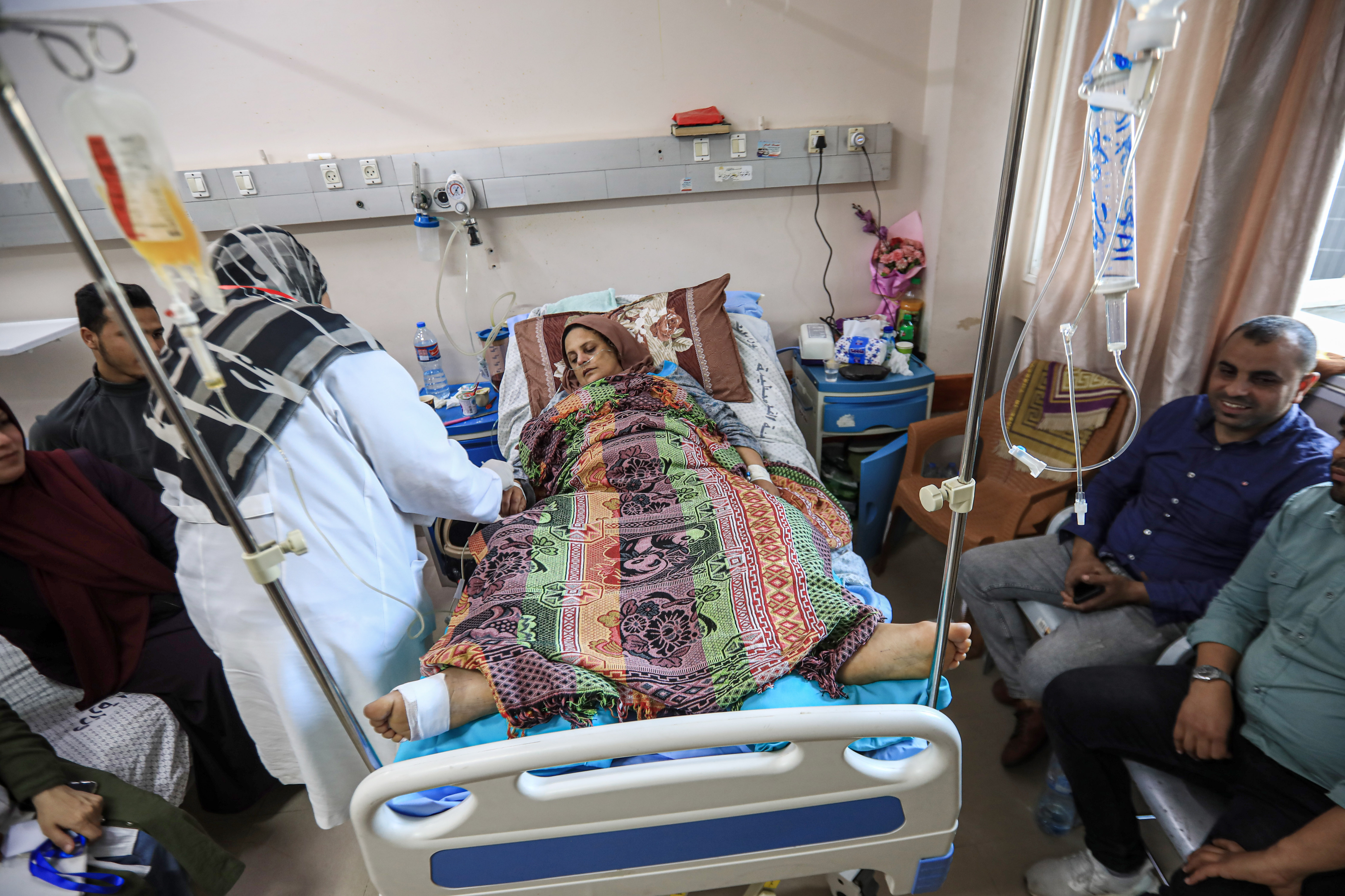 A woman in a hospital bed and a nurse