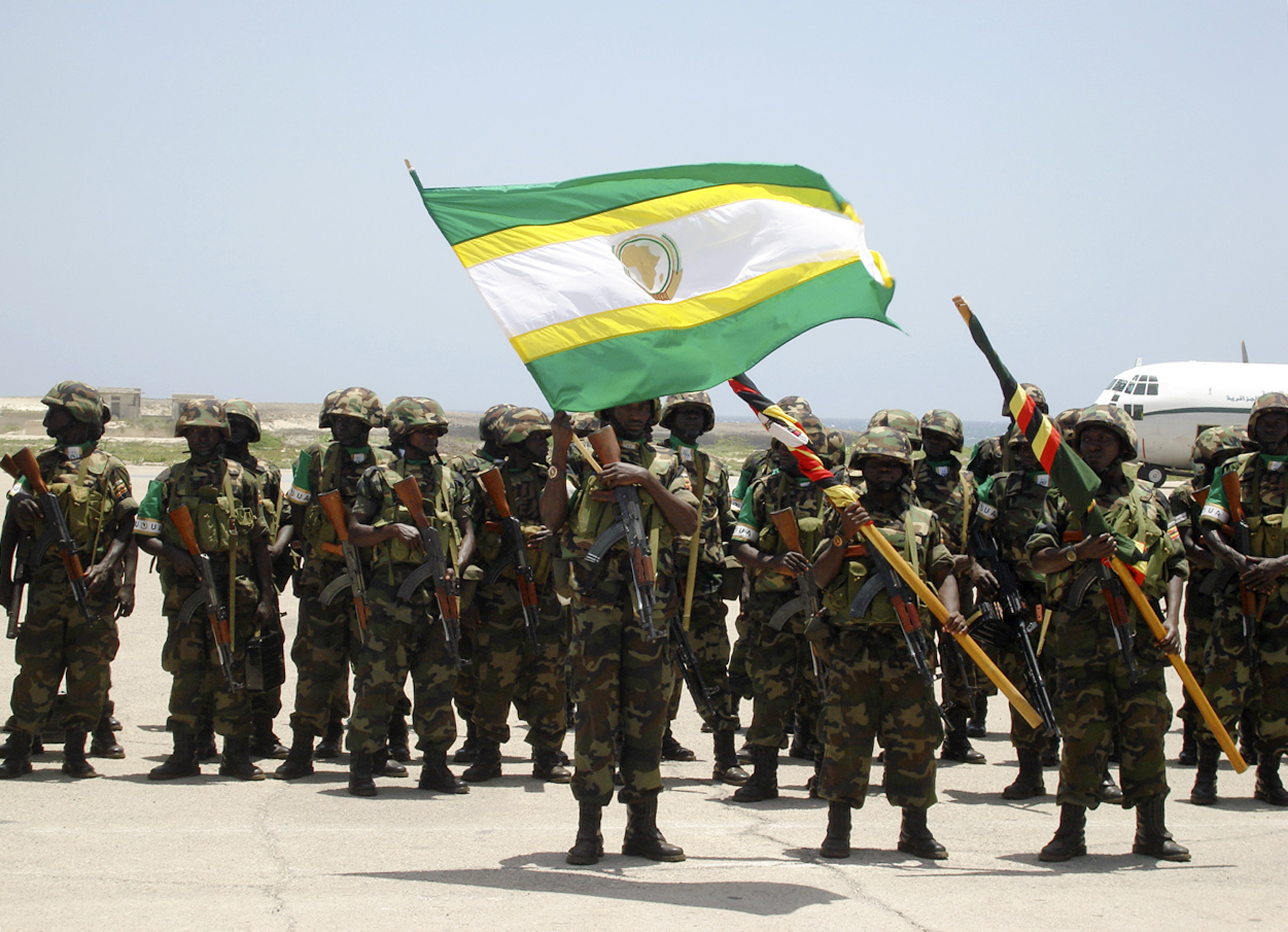 Ugandan soldiers, part of the African Union peacekeepers for Somalia, hold the flag of African Union at Mogadishu's international airport