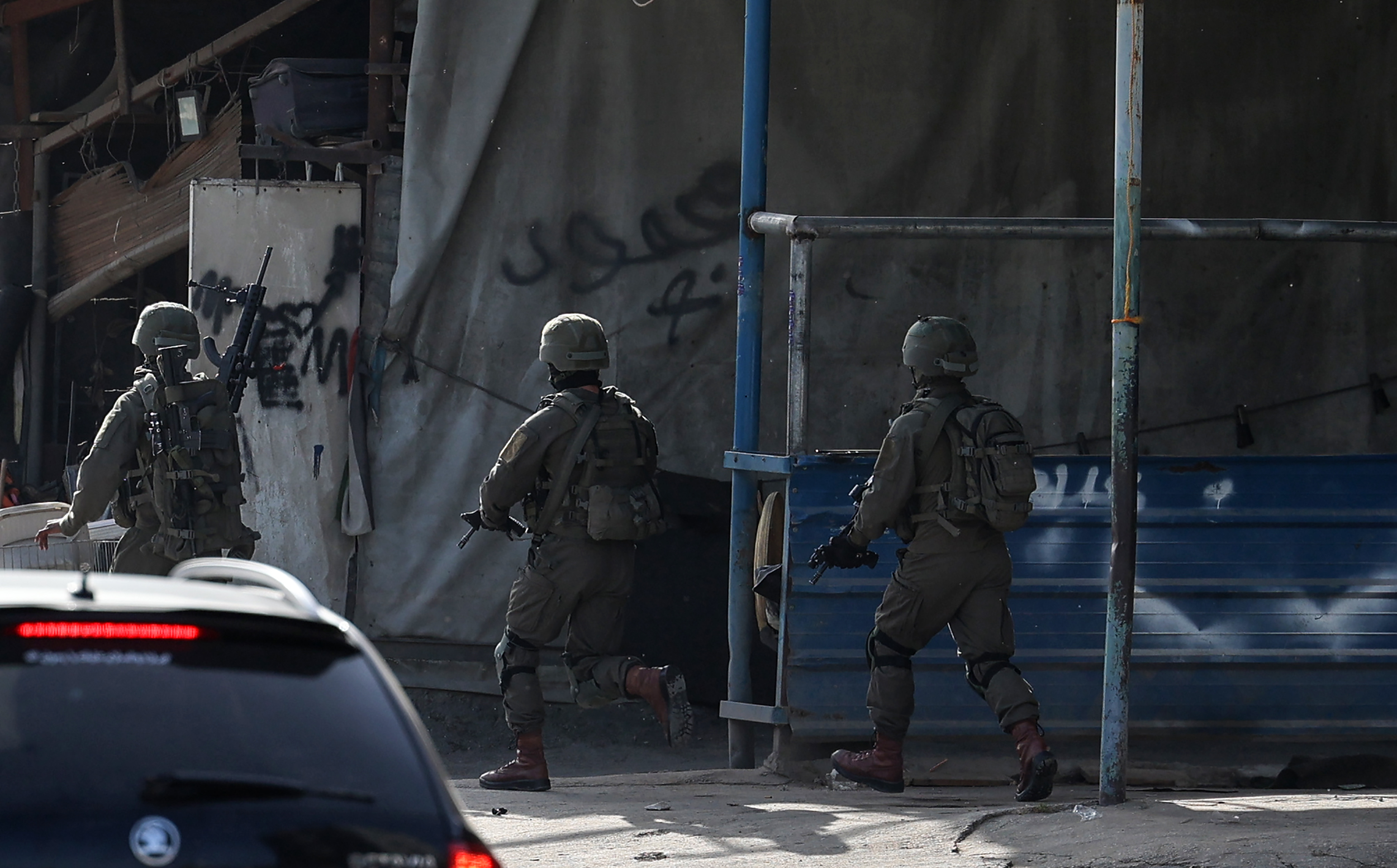 Israeli troops take position in the Nur Shams Palestinian refugee camp near in the northern West Bank town of Tulkarem on April 10,2022, during a raid looking for suspects related to a gunman from Jenin who went on a shooting rampage in a popular Tel Aviv nightlife area on April 7, killing three Israelis and wounding more than a dozen others. (Photo by JAAFAR ASHTIYEH / AFP)