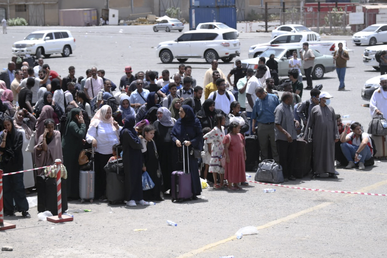 People fleeing war-torn Sudan queue to board a boat from Port Sudan