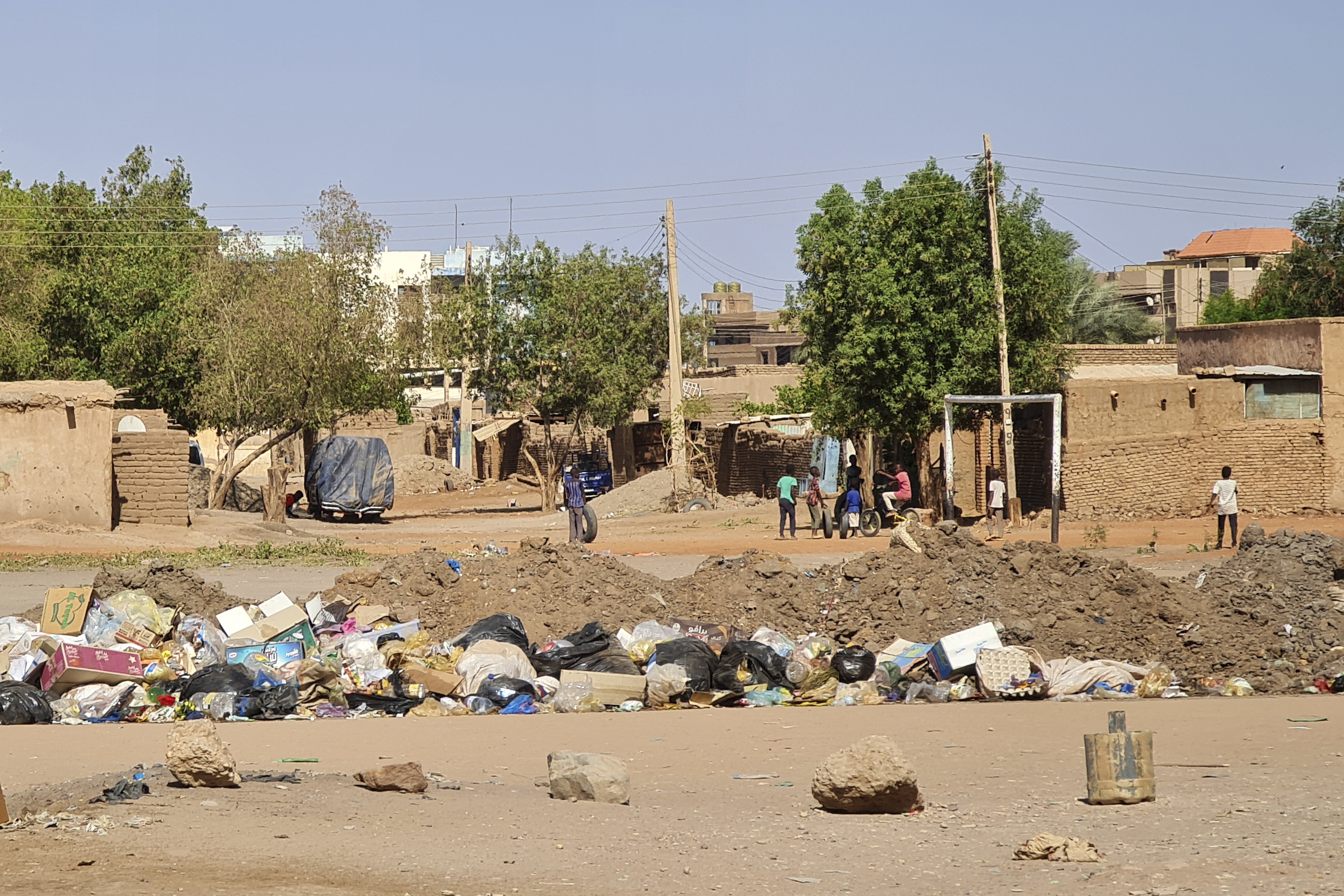 Youths play outdoors near a blocked road in southern Khartoum