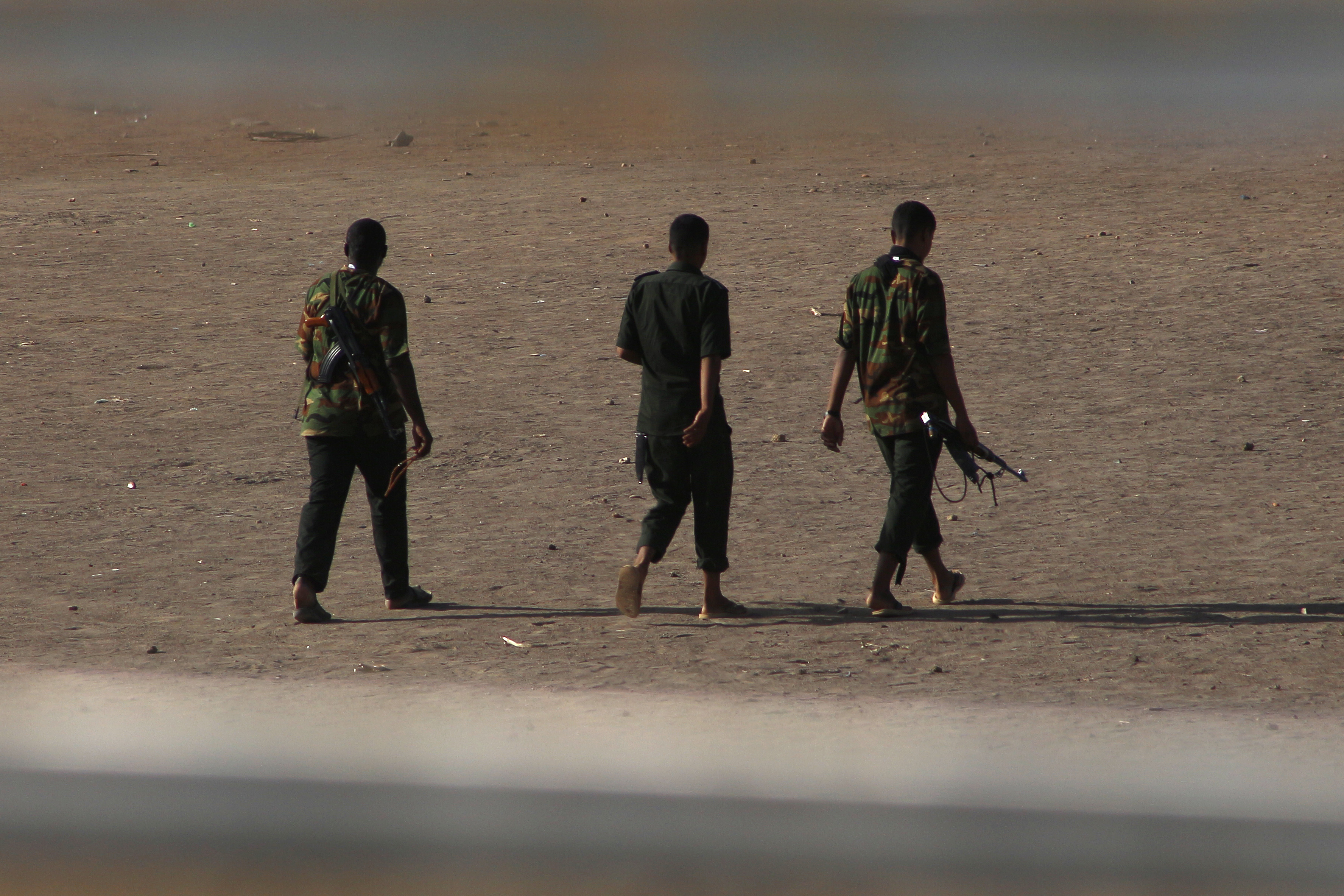 Armed men walk in Khartoum
