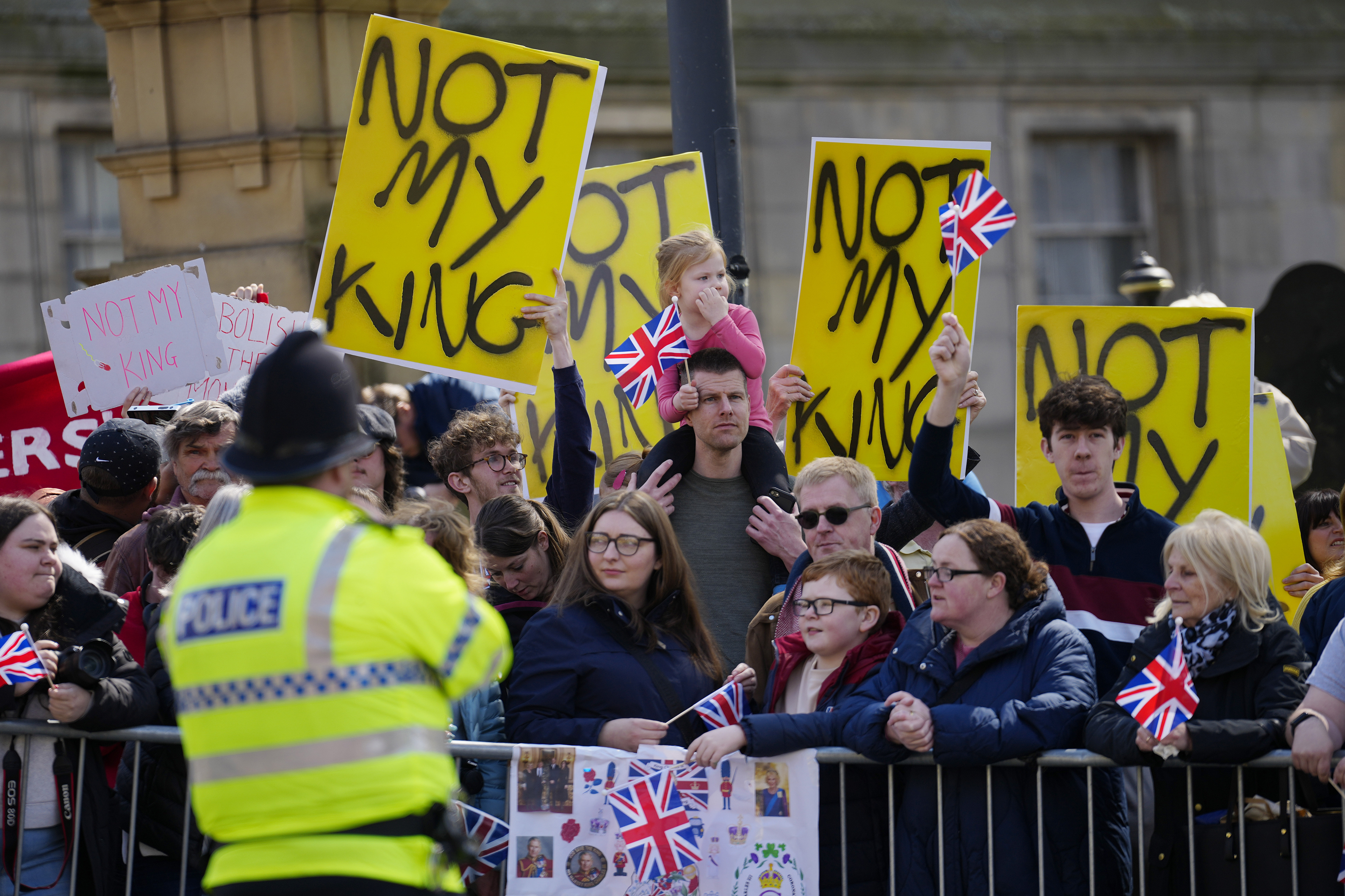 FILE - Protestors wait for the arrival of King Charles III and Camilla, the Queen Consort to visit Liverpool Central Library, and to officially mark the Library's twinning with Ukraine's first public Library, the Regional Scientific Library in Odesa, in Liverpool, England, Wednesday, April 26, 2023. There will be dissenters among the cheering crowds when King Charles III travels by gilded coach to his coronation. More than 1,500 protesters will be dressed in yellow for maximum visibility and they plan to gather beside it to chant “Not my king” as the royal procession goes by on Saturday. (AP Photo/Jon Super, Pool, File)